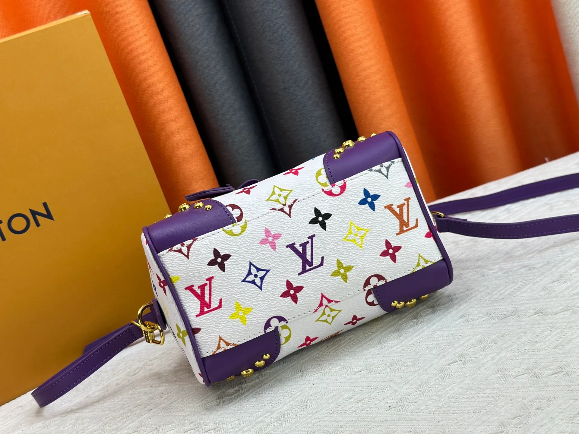 P260 upgraded original M58953 M46234 M46222 Speedy Bandoulière 20 handbag is made of soft coated canvas, and the full-length Monogram pattern is traced in colorful rainbow tones, highlighting the smart style of the Louis Vuitton x Murakami reissue series. The Toron handle and detachable shoulder strap are constructed of cow leather, the metal corners recall classic luggage elements, and the bow-shaped key bag and padlock add brand touches. Dimensions: 20.5 x 13.5 x 12.0 cm (length x height x width)