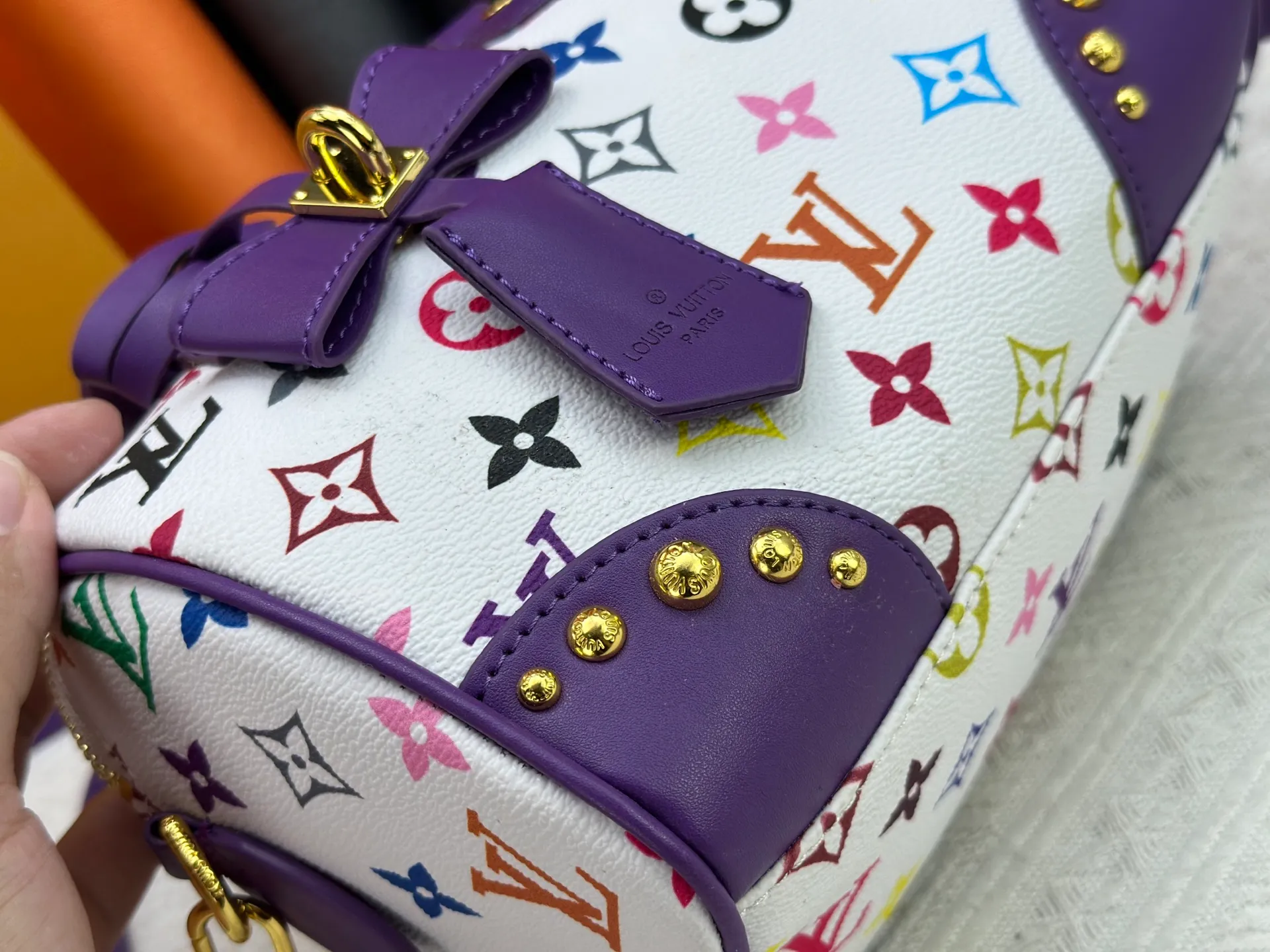 P260 upgraded original M58953 M46234 M46222 Speedy Bandoulière 20 handbag is made of soft coated canvas, and the full-length Monogram pattern is traced in colorful rainbow tones, highlighting the smart style of the Louis Vuitton x Murakami reissue series. The Toron handle and detachable shoulder strap are constructed of cow leather, the metal corners recall classic luggage elements, and the bow-shaped key bag and padlock add brand touches. Dimensions: 20.5 x 13.5 x 12.0 cm (length x height x width)