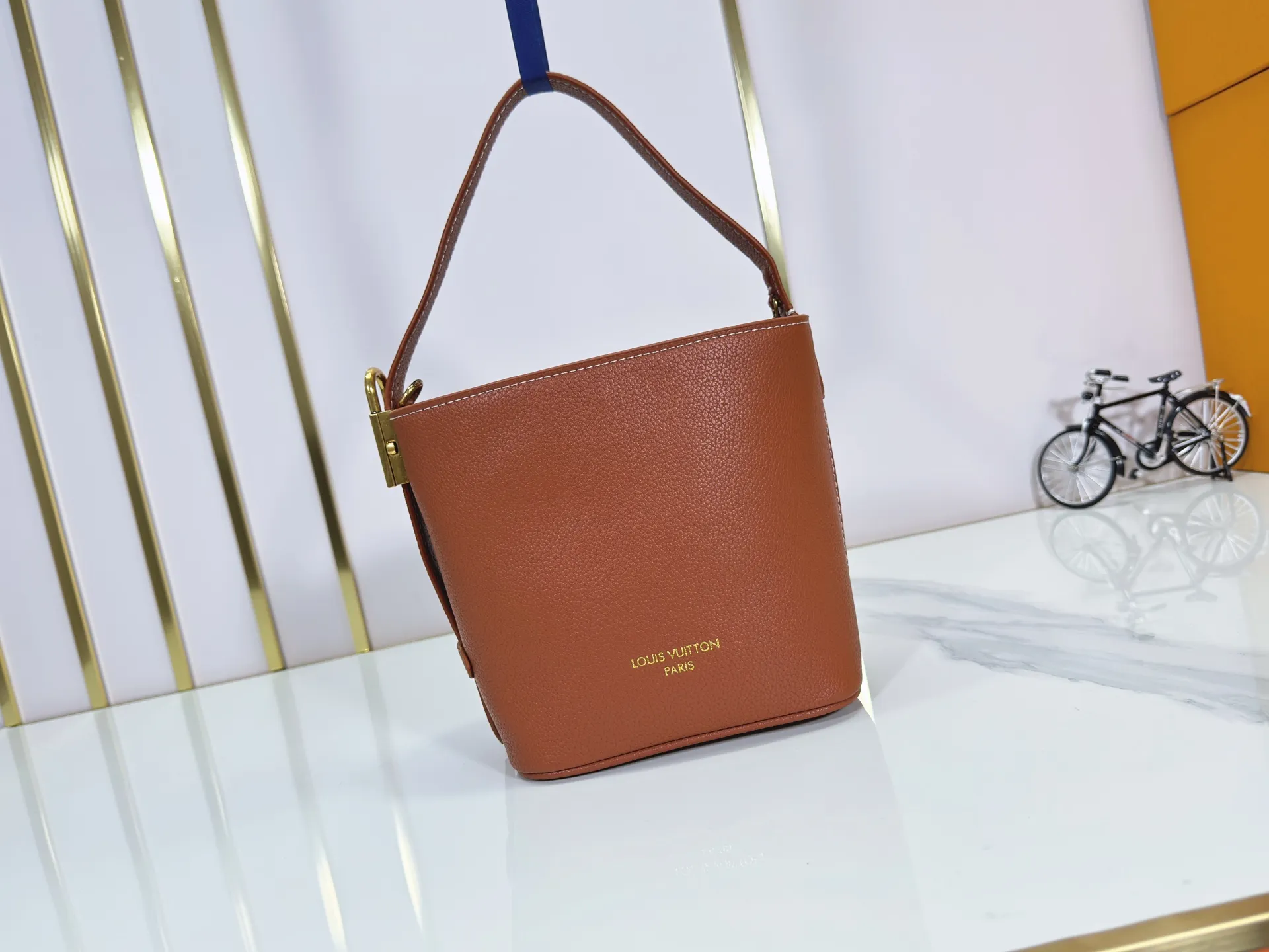 P260 Upgraded original version M25543, M14416, M12925 M25673 This All In BB handbag is from the Low Key series. It is made of grained cow leather to create a compact bucket bag configuration, which can be carried in various ways for day and night occasions. The distressed metal pieces convey a retro feel, while the padlock and detachable Monogram pocket highlight the brand's style. Size: 16*12*18cm