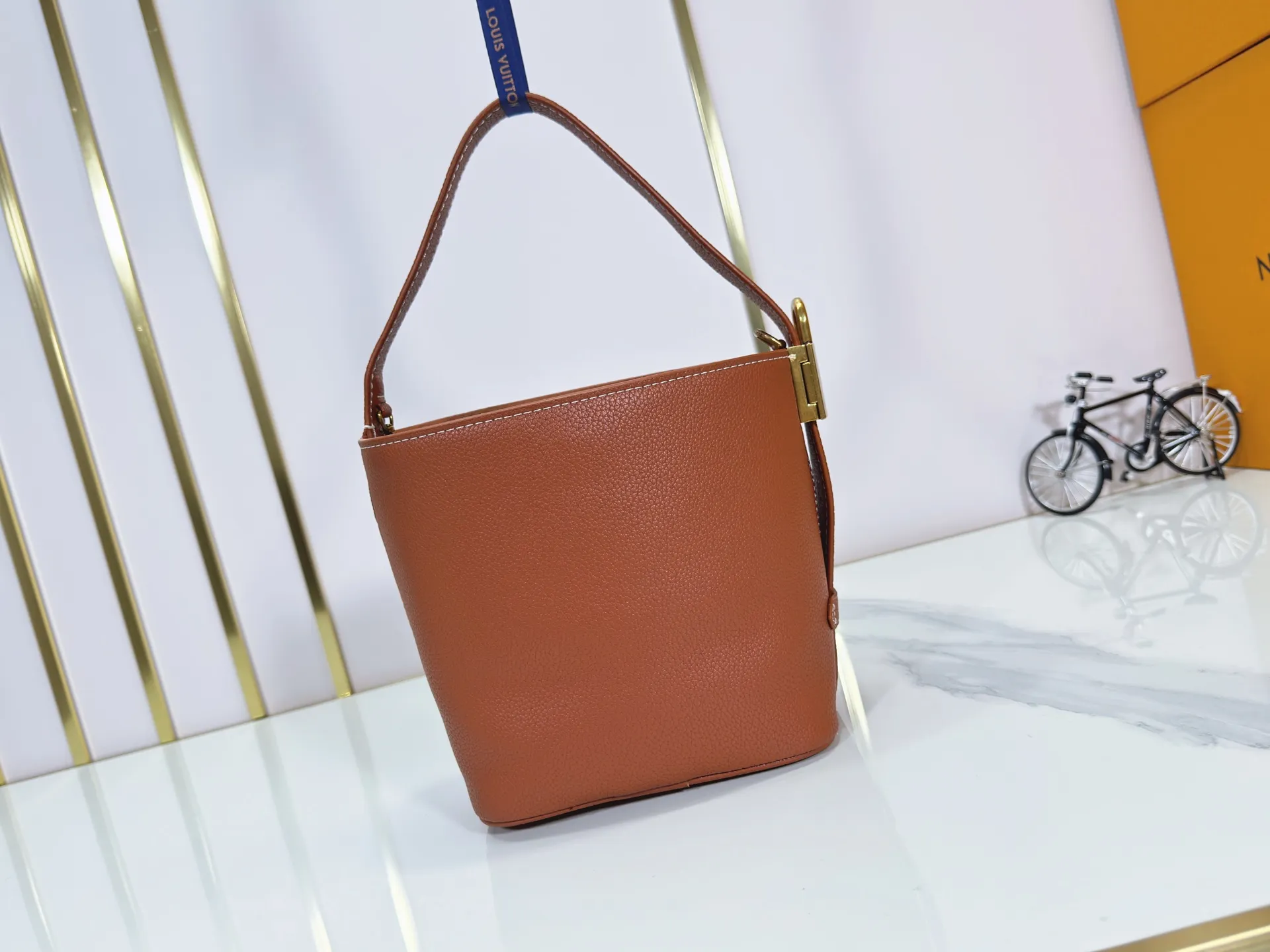 P260 Upgraded original version M25543, M14416, M12925 M25673 This All In BB handbag is from the Low Key series. It is made of grained cow leather to create a compact bucket bag configuration, which can be carried in various ways for day and night occasions. The distressed metal pieces convey a retro feel, while the padlock and detachable Monogram pocket highlight the brand's style. Size: 16*12*18cm
