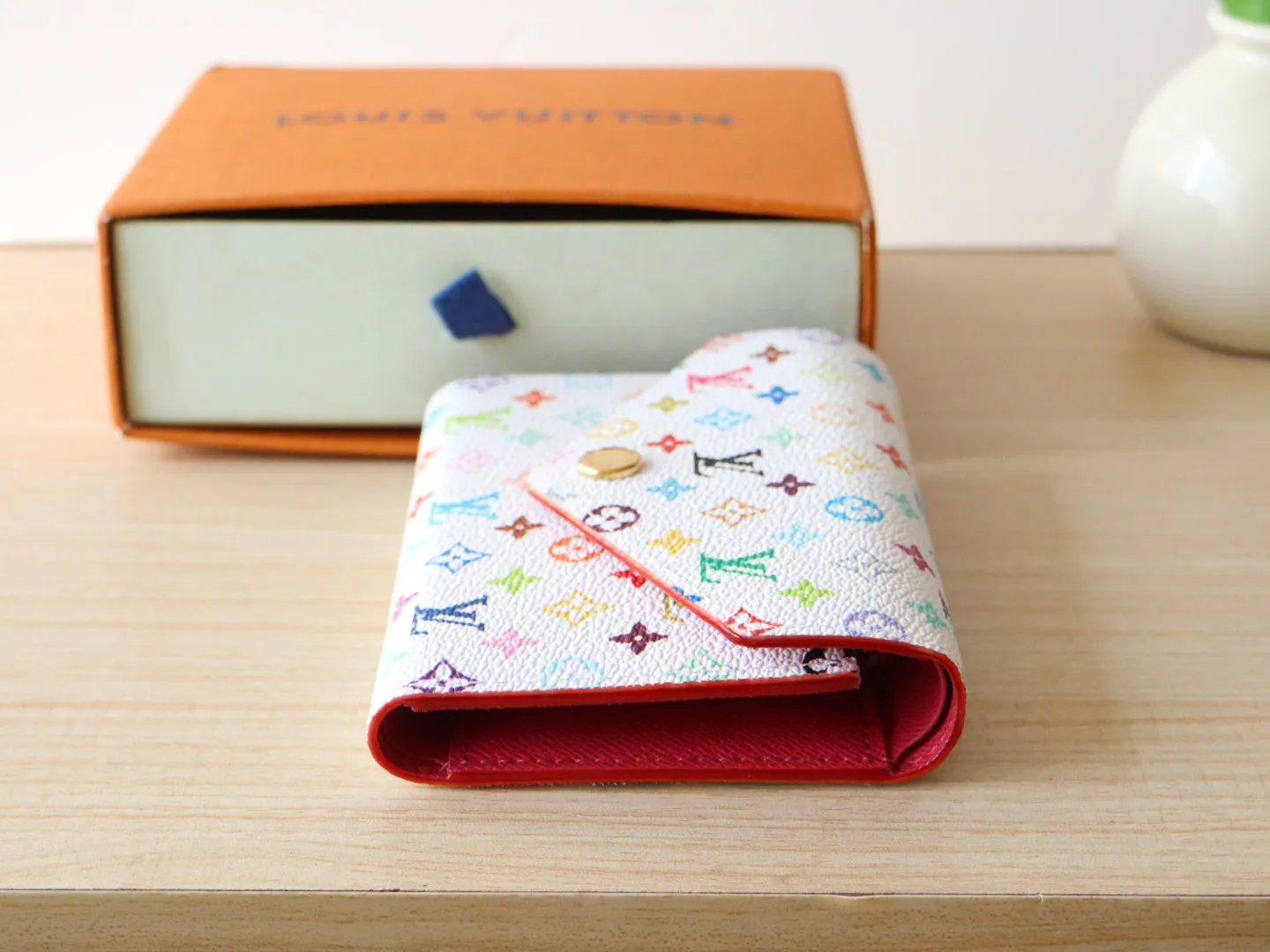14163 Tri-Color Tri-fold Wallet🌟P90 This replica version of the Victorine wallet from the Louis Vuitton x Murakami series is small and exquisite. The colorful Monogram pattern reinterprets Louis Vuitton's classic logo with the famous rainbow tones of Japanese artist Takashi Murakami. The wallet is made of coated canvas with fine cowhide lining and silver-tone hardware. It has a zippered coin compartment and multiple interior compartments for banknotes and business cards. 12 x 9.5 x 2.5 cm (length x height x width)