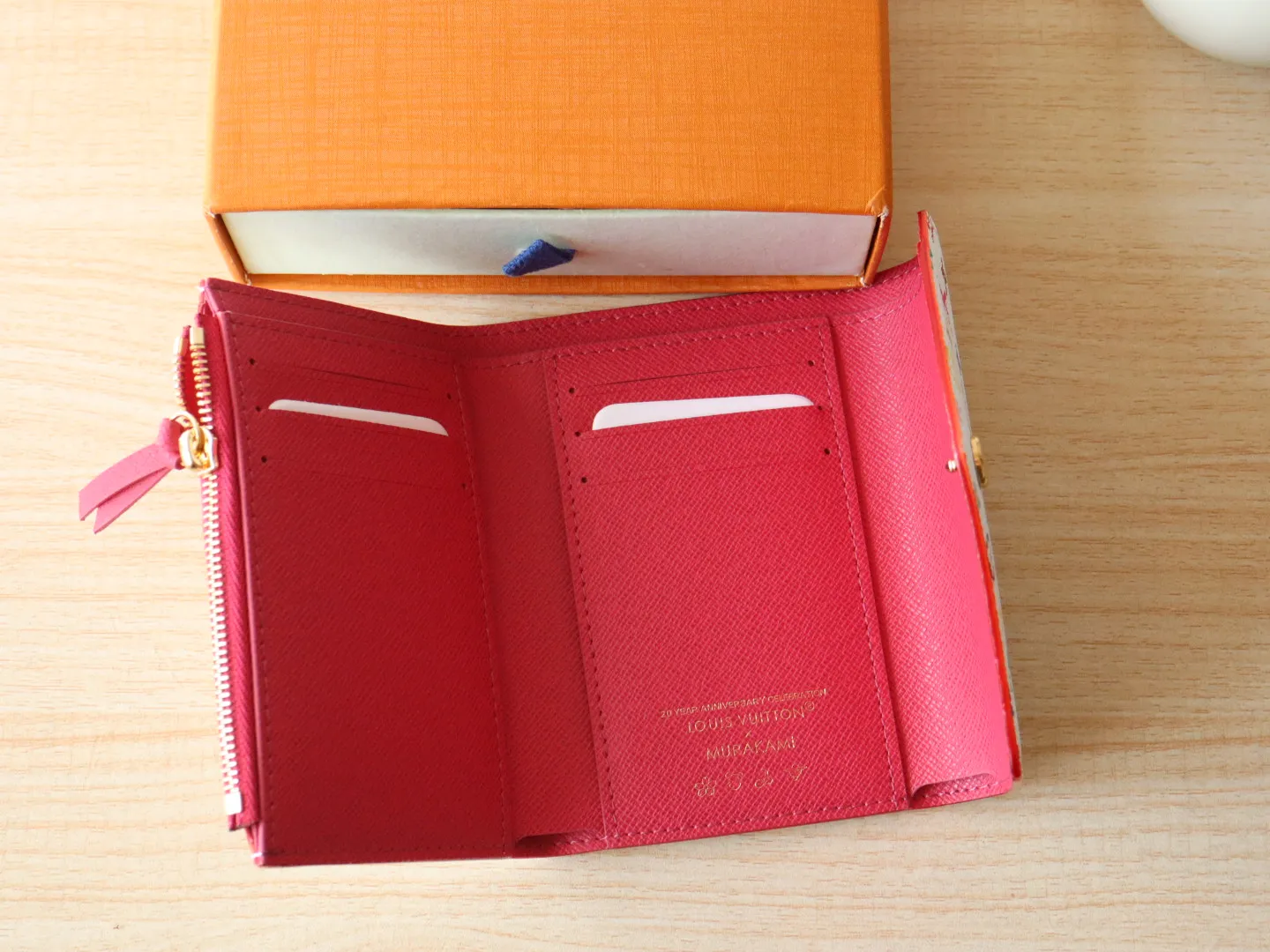 14163 Tri-Color Tri-fold Wallet🌟P90 This replica version of the Victorine wallet from the Louis Vuitton x Murakami series is small and exquisite. The colorful Monogram pattern reinterprets Louis Vuitton's classic logo with the famous rainbow tones of Japanese artist Takashi Murakami. The wallet is made of coated canvas with fine cowhide lining and silver-tone hardware. It has a zippered coin compartment and multiple interior compartments for banknotes and business cards. 12 x 9.5 x 2.5 cm (length x height x width)