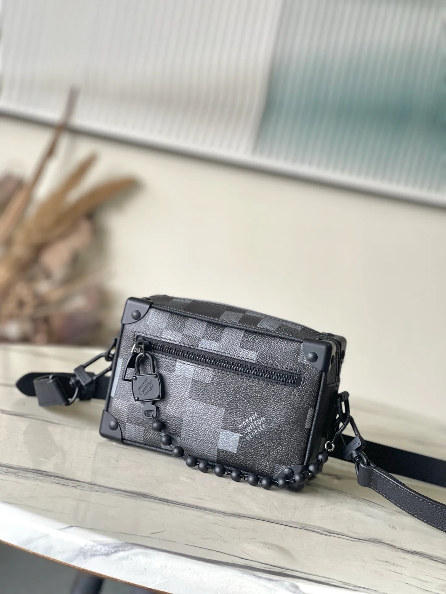 💰1180 Top Original Order M14922 This Mini Soft Trunk handbag is made of Damoflage Black coated canvas with cow leather trim. The compact body is decorated with the pixelated Damier pattern written by Pharrell Wiliams to fully interpret the modern style. The rolled leather top handle and detachable and adjustable shoulder strap provide a variety of carrying options. Dimensions: 18.5 × 13 × 8 cm