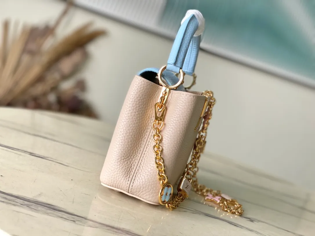 💰2200 (Special grade original leather) M23952 mini This Capucines mini handbag comes from the Lovelock Chain series. The Taurillon leather bag has a dotted rope that looks like a jewelry chain, with a padlock and pastel enamel Monogram flowers, echoing the dual tones of the leather. The detachable chain and top handle provide more carrying options, and the inner pocket is equipped with a small mirror for easy touch-ups at any time. Dimensions: 21 × 14 × 8 cm