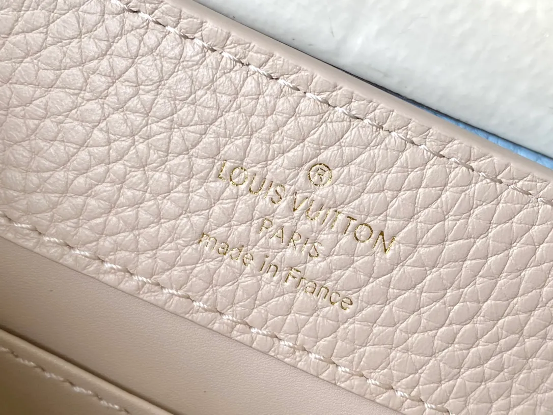 💰2200 (Special grade original leather) M23952 mini This Capucines mini handbag comes from the Lovelock Chain series. The Taurillon leather bag has a dotted rope that looks like a jewelry chain, with a padlock and pastel enamel Monogram flowers, echoing the dual tones of the leather. The detachable chain and top handle provide more carrying options, and the inner pocket is equipped with a small mirror for easy touch-ups at any time. Dimensions: 21 × 14 × 8 cm