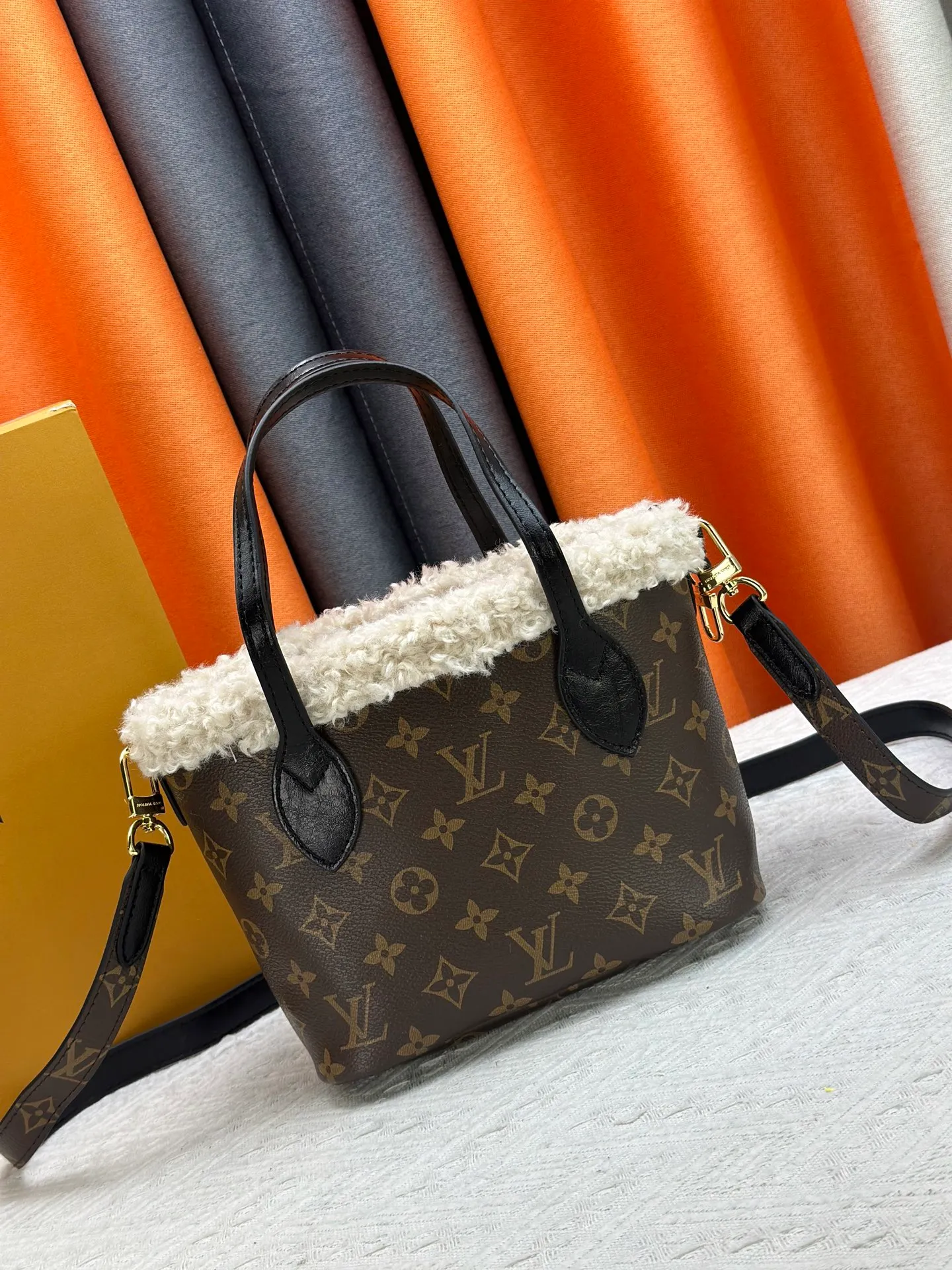 P340M26315 12099 Guangzhou upgraded version This Neverfull Bandoulière Inside Out BB handbag comes from the LV Ski series and is made of Monogram canvas with trendy shearling trim and lining. The Teddygram logo is laid out on it, creating a sophisticated style with dazzling metal parts. A zippered pocket adds a finishing touch to the reversible design, allowing it to be held individually. Long shoulder straps allow for cross-body comfort. 16.5 x 11 x 26.5 cm (height x width x length)