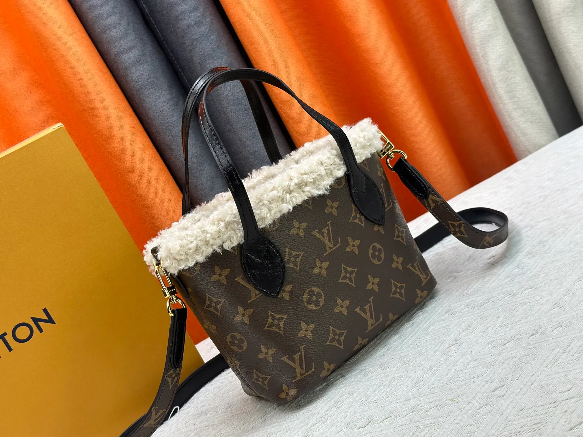 P340M26315 12099 Guangzhou upgraded version This Neverfull Bandoulière Inside Out BB handbag comes from the LV Ski series and is made of Monogram canvas with trendy shearling trim and lining. The Teddygram logo is laid out on it, creating a sophisticated style with dazzling metal parts. A zippered pocket adds a finishing touch to the reversible design, allowing it to be held individually. Long shoulder straps allow for cross-body comfort. 16.5 x 11 x 26.5 cm (height x width x length)