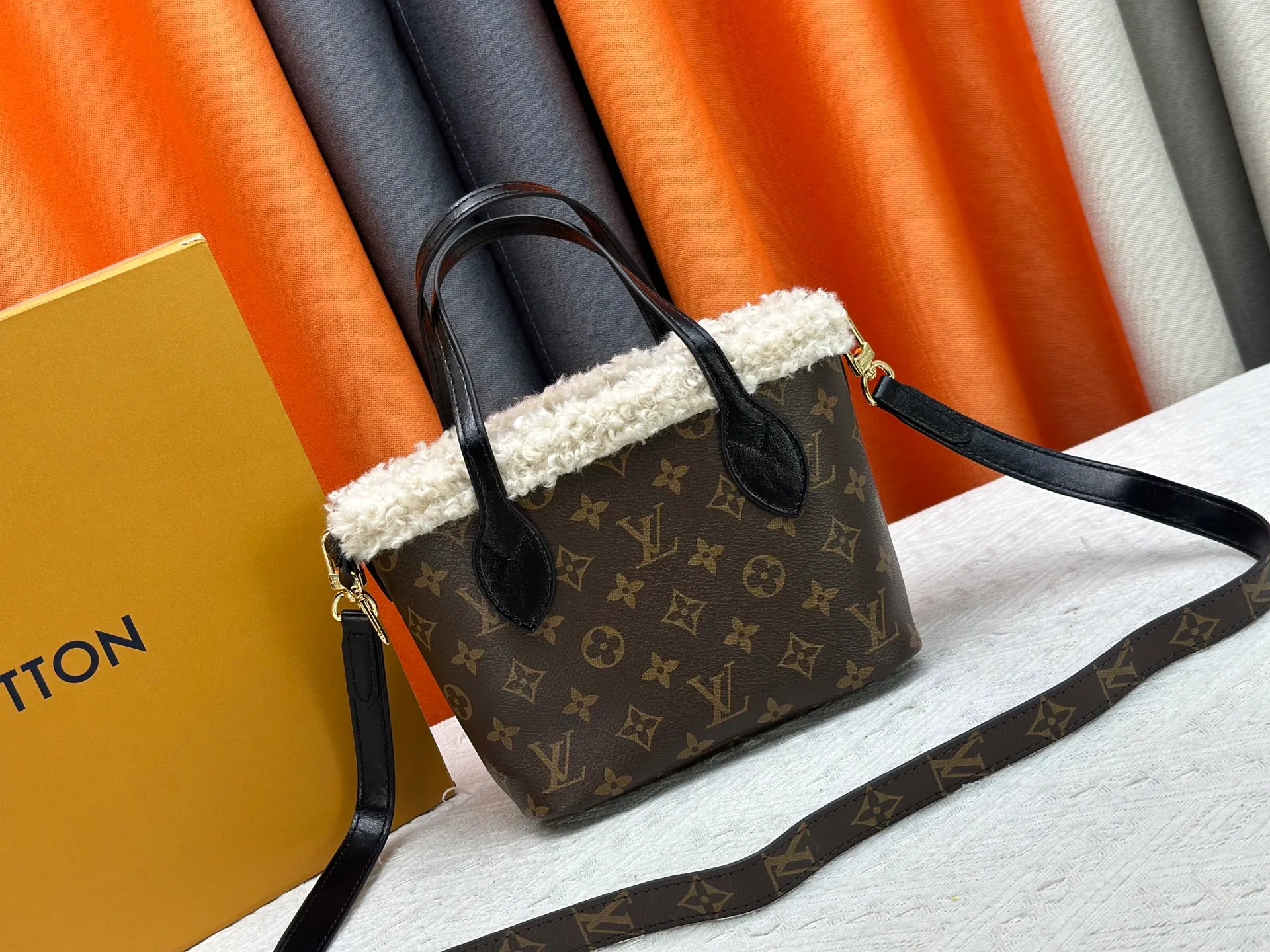 P340M26315 12099 Guangzhou upgraded version This Neverfull Bandoulière Inside Out BB handbag comes from the LV Ski series and is made of Monogram canvas with trendy shearling trim and lining. The Teddygram logo is laid out on it, creating a sophisticated style with dazzling metal parts. A zippered pocket adds a finishing touch to the reversible design, allowing it to be held individually. Long shoulder straps allow for cross-body comfort. 16.5 x 11 x 26.5 cm (height x width x length)