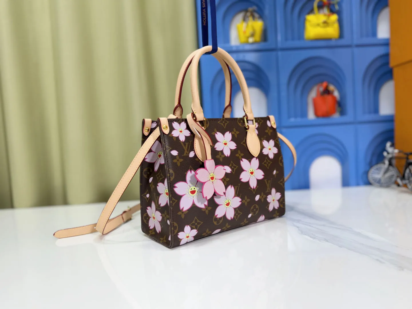 P240 M45659 M13668!🔥Lv&Takashi Murakami🐼Sakura🌸OnTheGo Small new version The legendary ONTHEGO handbag: always able to meet your various needs for handbags. It has a large capacity but is not bulky. It is stiff and soft to the touch, making it suitable for home and travel. Tighten the side ties and it instantly transforms into a stylish urban handbag. Loosen the straps and it transforms into a chic and practical handbag. The slender leather handle can be carried over the shoulder or between the arms. The model shown here is made of Damier Azur canvas. Size: 25x11x19cm