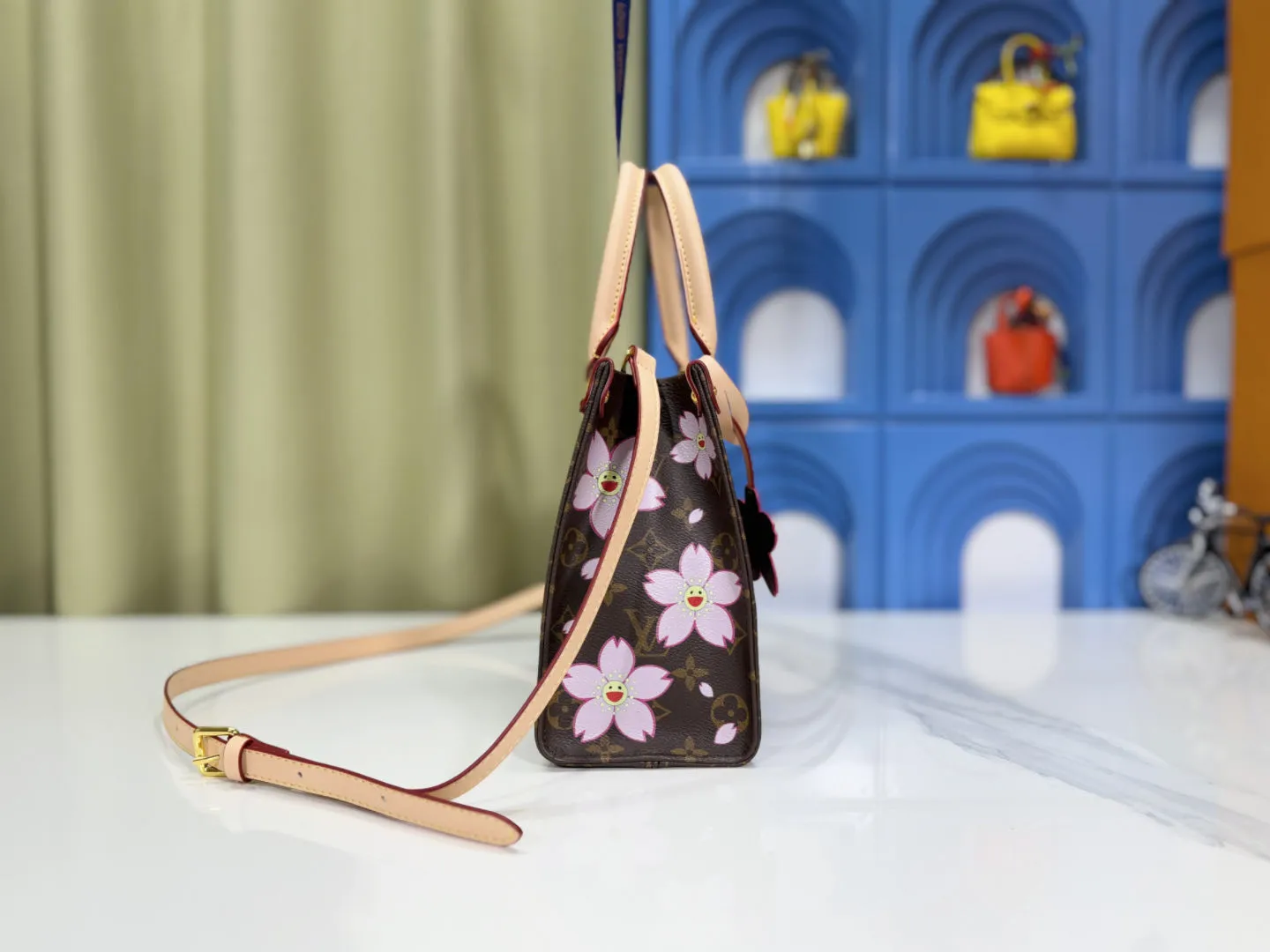P240 M45659 M13668!🔥Lv&Takashi Murakami🐼Sakura🌸OnTheGo Small new version The legendary ONTHEGO handbag: always able to meet your various needs for handbags. It has a large capacity but is not bulky. It is stiff and soft to the touch, making it suitable for home and travel. Tighten the side ties and it instantly transforms into a stylish urban handbag. Loosen the straps and it transforms into a chic and practical handbag. The slender leather handle can be carried over the shoulder or between the arms. The model shown here is made of Damier Azur canvas. Size: 25x11x19cm