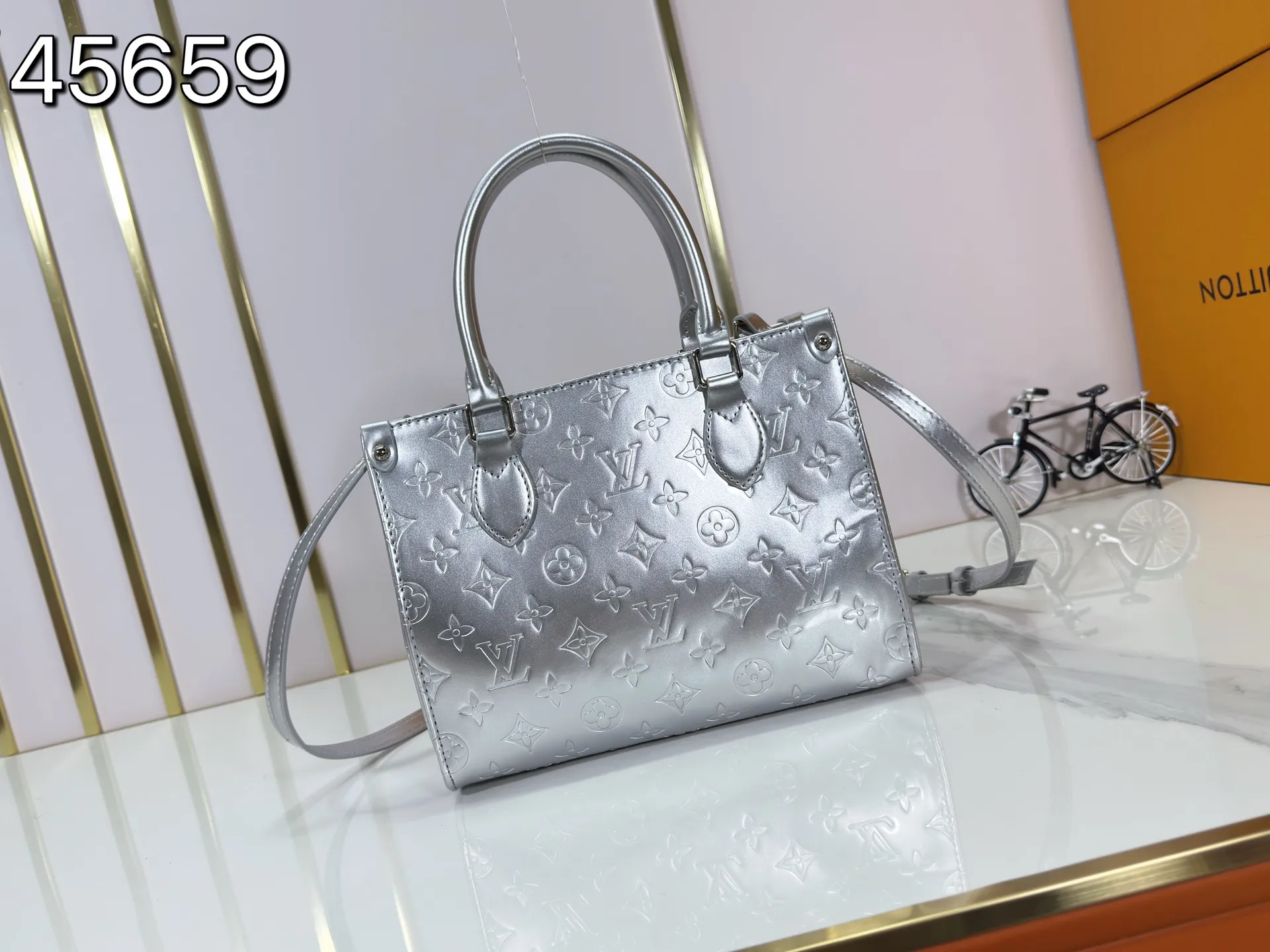 P220 upgraded original M26373 M45659 M44571 This OnTheGo small handbag joins the LV Ski series in the Monogram Miroir version. Laminated canvas ensures durability. Silver hues and tonal hardware create a gleaming look. Built-in pockets can store daily necessities such as small books. Dimensions: 25 x 19 x 11.5 (cm) ((length x height x width)