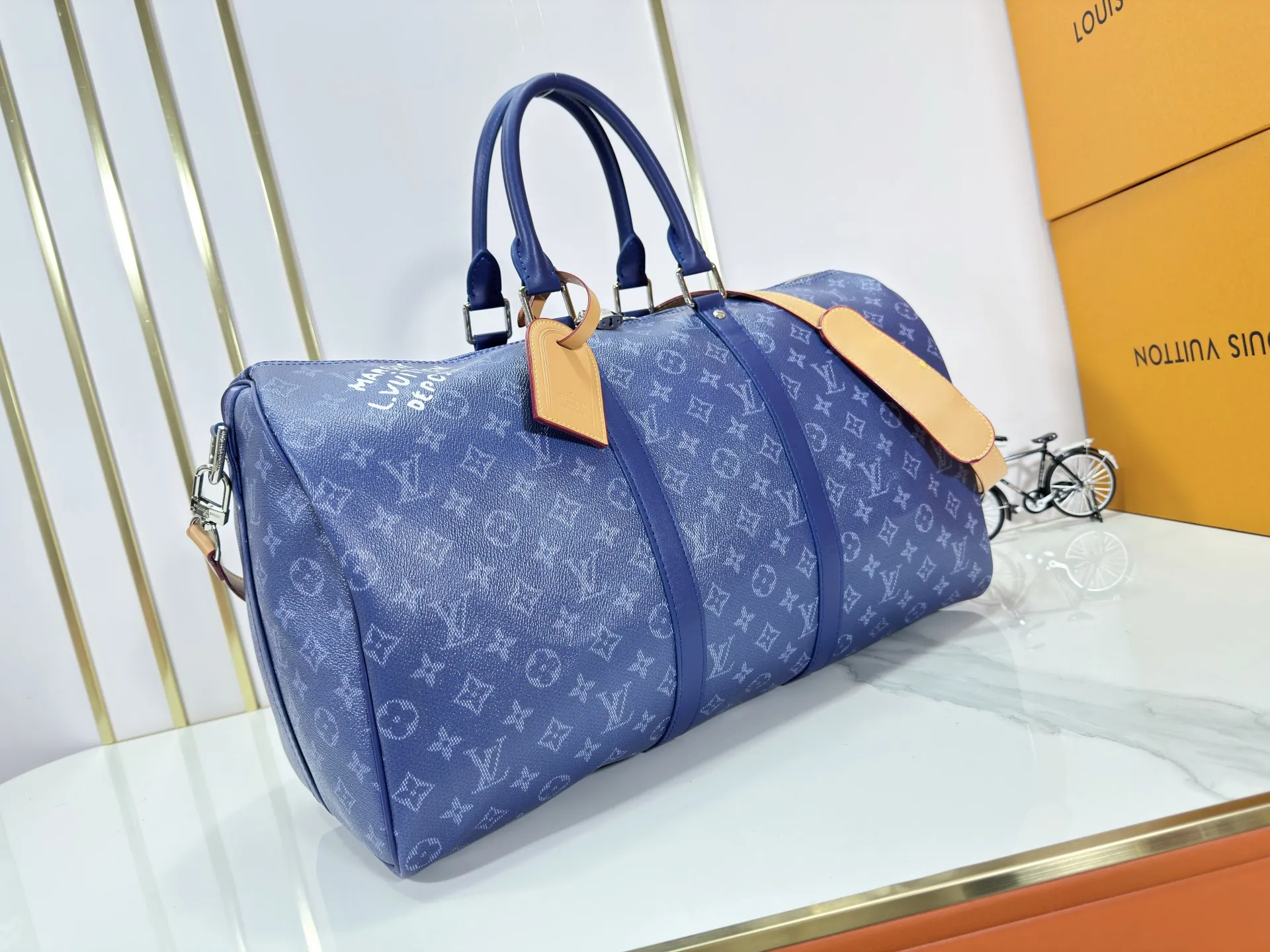P340 Upgraded original M26864 M26865 M26866 This Keepall Bandoulière 50 travel bag is made of Monogram Heritage canvas dip-dyed in colorful colors, with cowhide trim, leather shoulder straps, removable leather nameplate and cotton lining. The Marque L.Vuitton Déposée logo pays homage to Louis Vuitton’s rich heritage.  29 x 23 x 50 cm (H x W x L) Monogram Heritage coated canvas Cow leather trim Textile lining Metal hardware Carry-on baggage dimensions Double zip closure Padlock Removable name tag Internal zip pocket Handles: Double handles
