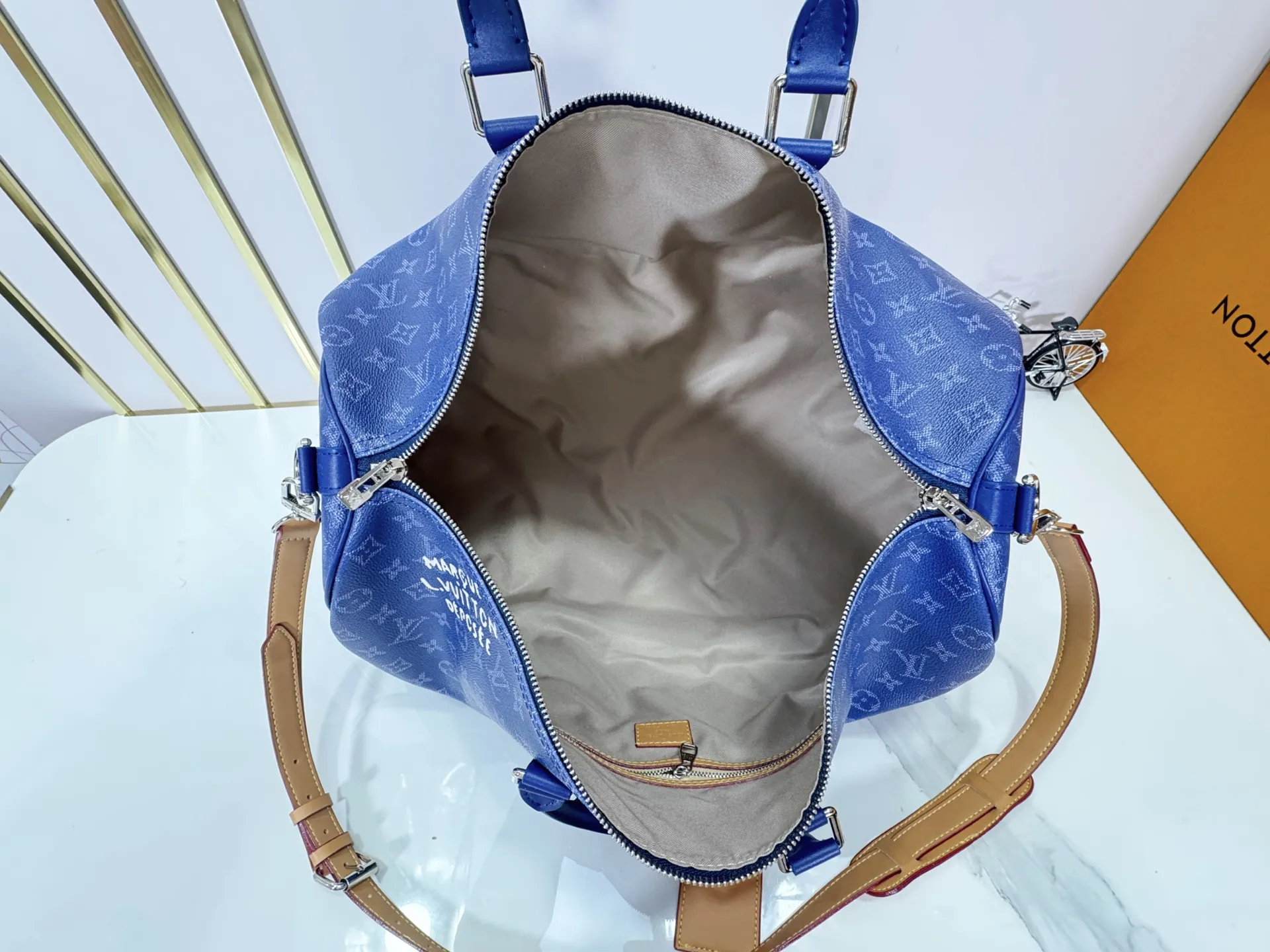 P340 Upgraded original M26864 M26865 M26866 This Keepall Bandoulière 50 travel bag is made of Monogram Heritage canvas dip-dyed in colorful colors, with cowhide trim, leather shoulder straps, removable leather nameplate and cotton lining. The Marque L.Vuitton Déposée logo pays homage to Louis Vuitton’s rich heritage.  29 x 23 x 50 cm (H x W x L) Monogram Heritage coated canvas Cow leather trim Textile lining Metal hardware Carry-on baggage dimensions Double zip closure Padlock Removable name tag Internal zip pocket Handles: Double handles