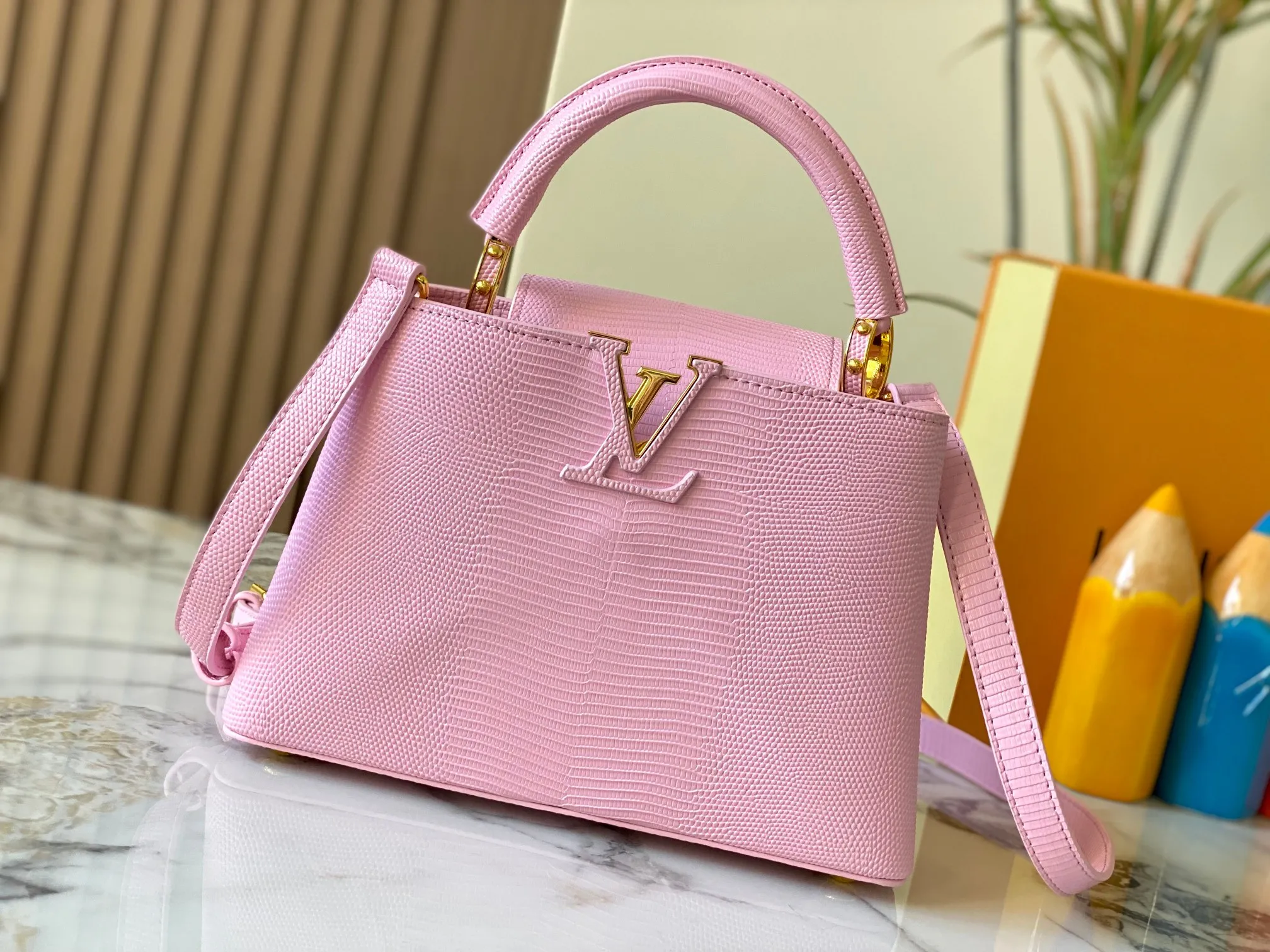 Top original P440 Guangzhou-made M99528 pink lizard skin gold buckle CapucinesBB handbag exquisitely combines graceful lizard skin outer layer, delicate sheepskin lining and glossy metal parts. The iconic flap makes two styles fashionable. The LV logo can be read on the inside and Monogram flowers bloom on the outside. It can light up an eye-catching corner for evening occasions and add a personalized atmosphere to the wardrobe. Shine gorgeous style in day and night occasions.  Detailed features 27 x 18 x 9 cm (length x height x width)