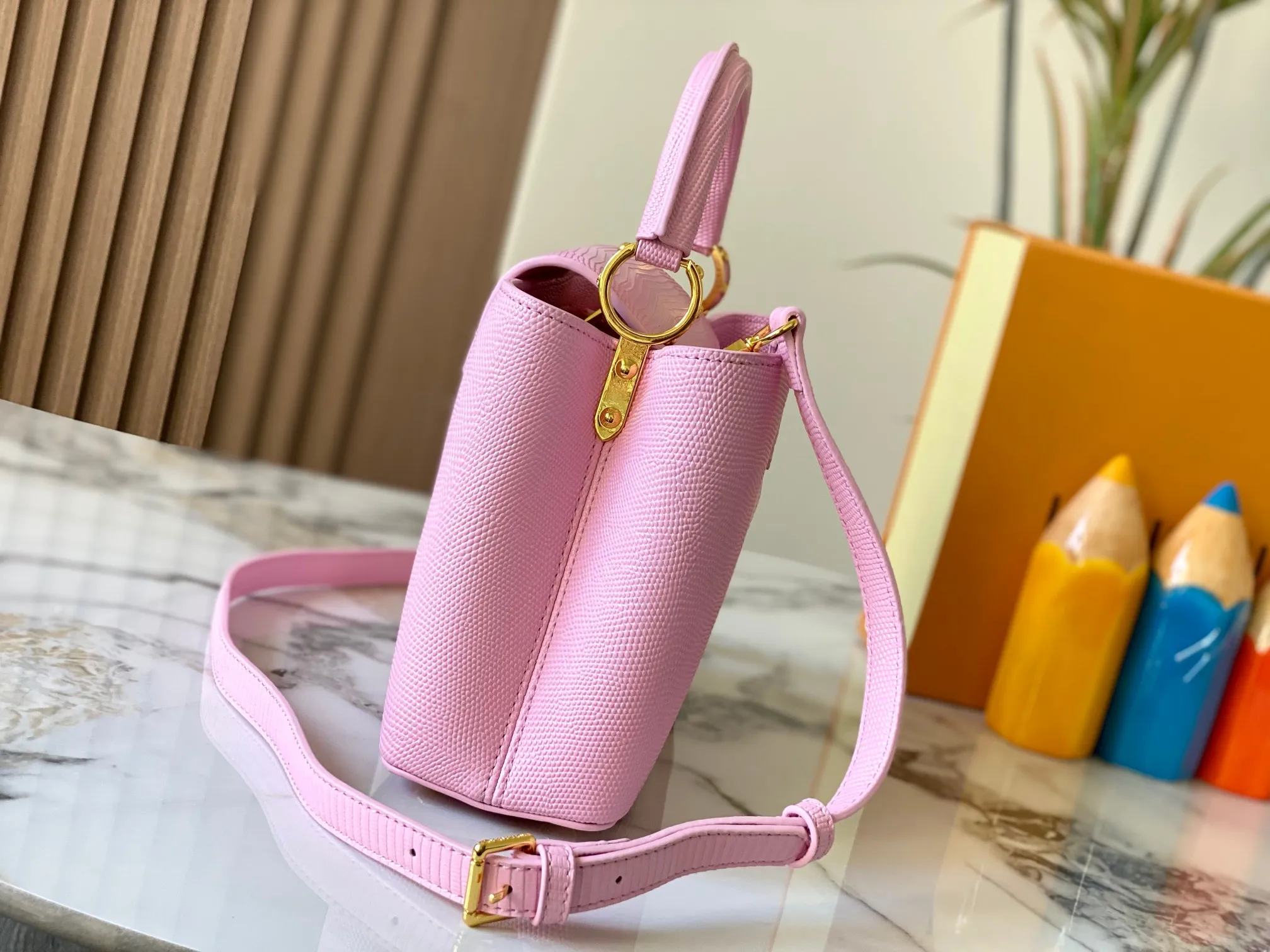 Top original P440 Guangzhou-made M99528 pink lizard skin gold buckle CapucinesBB handbag exquisitely combines graceful lizard skin outer layer, delicate sheepskin lining and glossy metal parts. The iconic flap makes two styles fashionable. The LV logo can be read on the inside and Monogram flowers bloom on the outside. It can light up an eye-catching corner for evening occasions and add a personalized atmosphere to the wardrobe. Shine gorgeous style in day and night occasions.  Detailed features 27 x 18 x 9 cm (length x height x width)