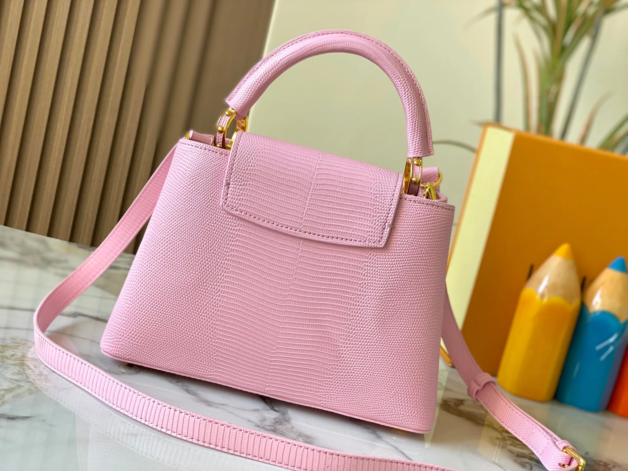 Top original P440 Guangzhou-made M99528 pink lizard skin gold buckle CapucinesBB handbag exquisitely combines graceful lizard skin outer layer, delicate sheepskin lining and glossy metal parts. The iconic flap makes two styles fashionable. The LV logo can be read on the inside and Monogram flowers bloom on the outside. It can light up an eye-catching corner for evening occasions and add a personalized atmosphere to the wardrobe. Shine gorgeous style in day and night occasions.  Detailed features 27 x 18 x 9 cm (length x height x width)