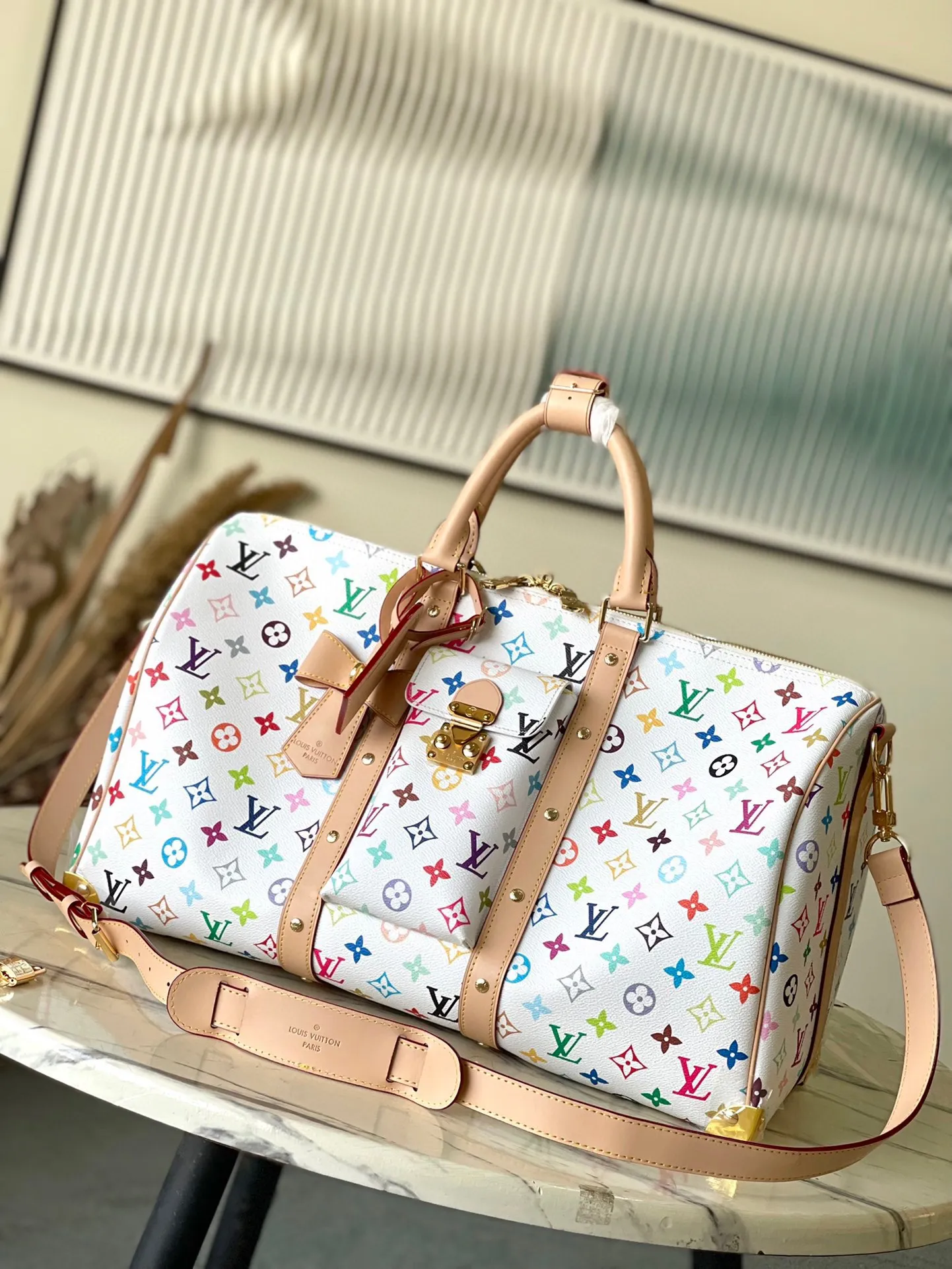 💰1740 Top original order M13742 This Keepal Bandouliere45 travel bag is from the Louis Vuitton × Murakami reissue series. It uses gorgeous Monogram coated canvas to show the creative blend of the brand's iconic elements and the artist's iridescent aesthetics. The S-lock buckle and glossy metal corners on the front pocket establish a classic foundation, while the rivet ribbon and bow-shaped key bag highlight the new season trend. Dimensions: 45 × 27 × 20 cm