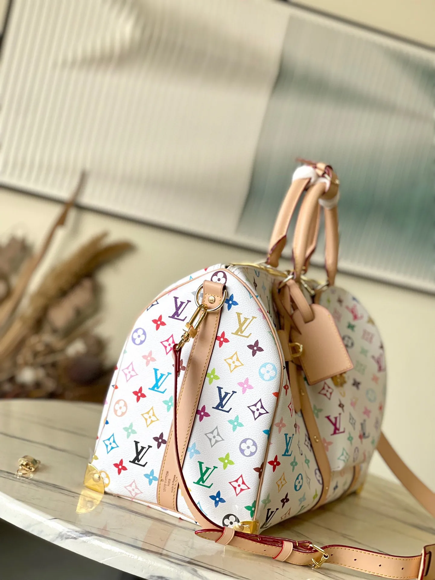 💰1740 Top original order M13742 This Keepal Bandouliere45 travel bag is from the Louis Vuitton × Murakami reissue series. It uses gorgeous Monogram coated canvas to show the creative blend of the brand's iconic elements and the artist's iridescent aesthetics. The S-lock buckle and glossy metal corners on the front pocket establish a classic foundation, while the rivet ribbon and bow-shaped key bag highlight the new season trend. Dimensions: 45 × 27 × 20 cm