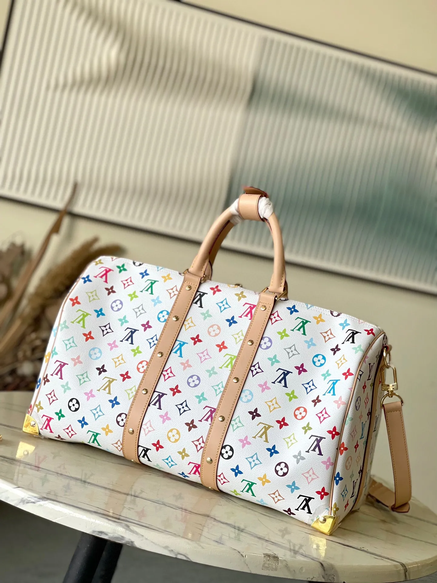 💰1740 Top original order M13742 This Keepal Bandouliere45 travel bag is from the Louis Vuitton × Murakami reissue series. It uses gorgeous Monogram coated canvas to show the creative blend of the brand's iconic elements and the artist's iridescent aesthetics. The S-lock buckle and glossy metal corners on the front pocket establish a classic foundation, while the rivet ribbon and bow-shaped key bag highlight the new season trend. Dimensions: 45 × 27 × 20 cm