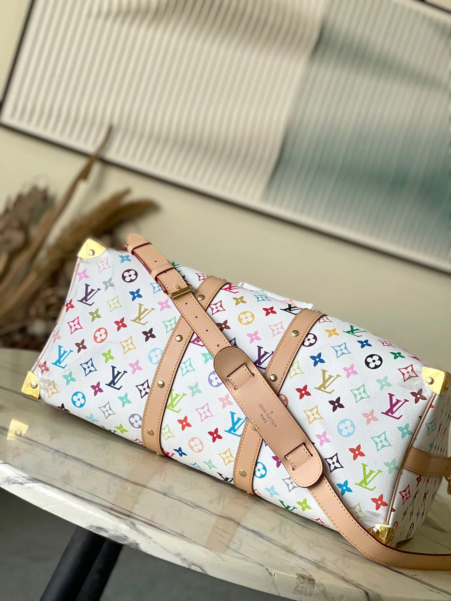 💰1740 Top original order M13742 This Keepal Bandouliere45 travel bag is from the Louis Vuitton × Murakami reissue series. It uses gorgeous Monogram coated canvas to show the creative blend of the brand's iconic elements and the artist's iridescent aesthetics. The S-lock buckle and glossy metal corners on the front pocket establish a classic foundation, while the rivet ribbon and bow-shaped key bag highlight the new season trend. Dimensions: 45 × 27 × 20 cm