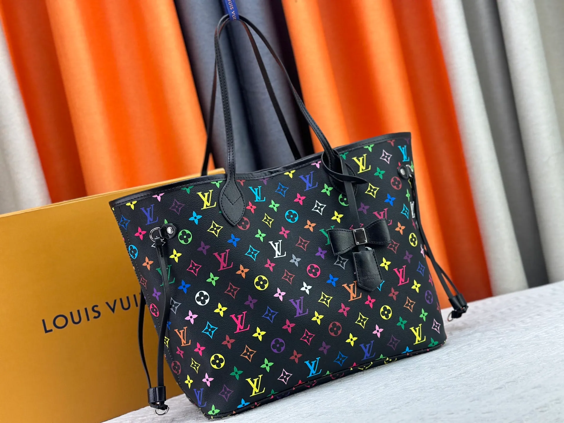 P260 Upgraded original M13675 M13271 M40995 This medium-sized Neverfull handbag is from the Louis Vuitton x Takashi Murakami reissue series. It uses Monogram canvas to create a spacious configuration, and then uses the smart Monogram floral pattern to interpret the artist's "ultra-flat" aesthetic style. Cowhide leather outlines the upper edge, handles and side straps, while the fabric lining incorporates colorful stripes. An interior zip pocket and a removable storage bag complete the functional design. Dimensions: 31.0 x 28.0 x 14.0 cm (length x height x width)