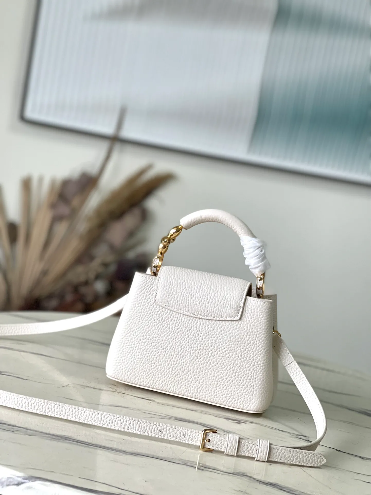 💰2160 (Special Grade Original Leather) M23944 White Mini This Capucines mini handbag incorporates delicate Monogram flowers into the handle, and uses delicate brushstrokes to present the three-dimensional look of the LV logo, injecting dazzling light into the soft design. Full-grain Taurillon leather has a compact shape that can hold a smartphone, short wallet and other small essentials. Dimensions: 21 × 14 × 8 cm