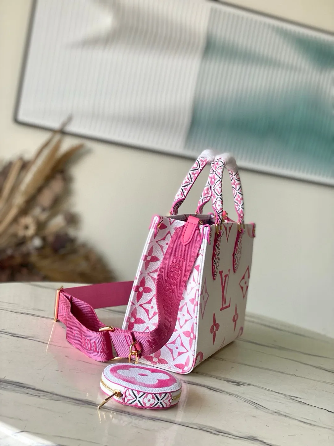 💰960 Top Original M22976 Pink This OnTheGo small handbag is made of canvas with a light Giant Monogram pattern, and detailed Monogram flowers are traced on the trim and top handle, showing the inspiration of traditional Portuguese tiles. Removable and adjustable shoulder strap for comfortable shoulder carrying experience. Dimensions: 25 x 19 x 11.5 cm