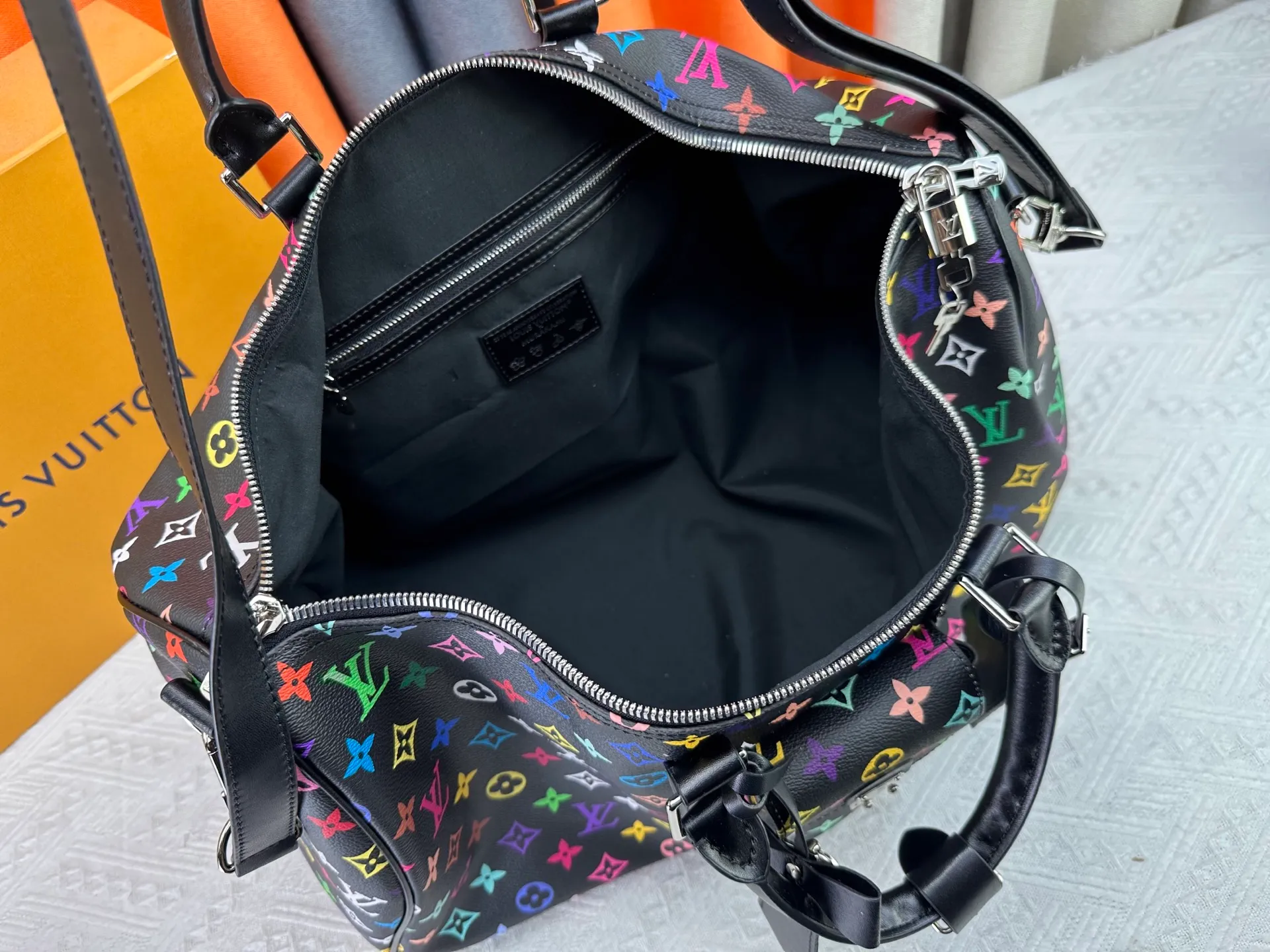 P480 ✨Guangzhou goods M13742 white color black color travel bag new season LV x TM KEEPALL BANDOULIÈRE 45 travel bag This Keepall Bandoulière 45 Jh travel bag is from the Louis Vuitton The S-lock buckle and glossy metal corners on the front pocket establish a classic foundation, while the rivet ribbon and bow-shaped key bag highlight the new season trend. 27 x 20 x 45 cm.
