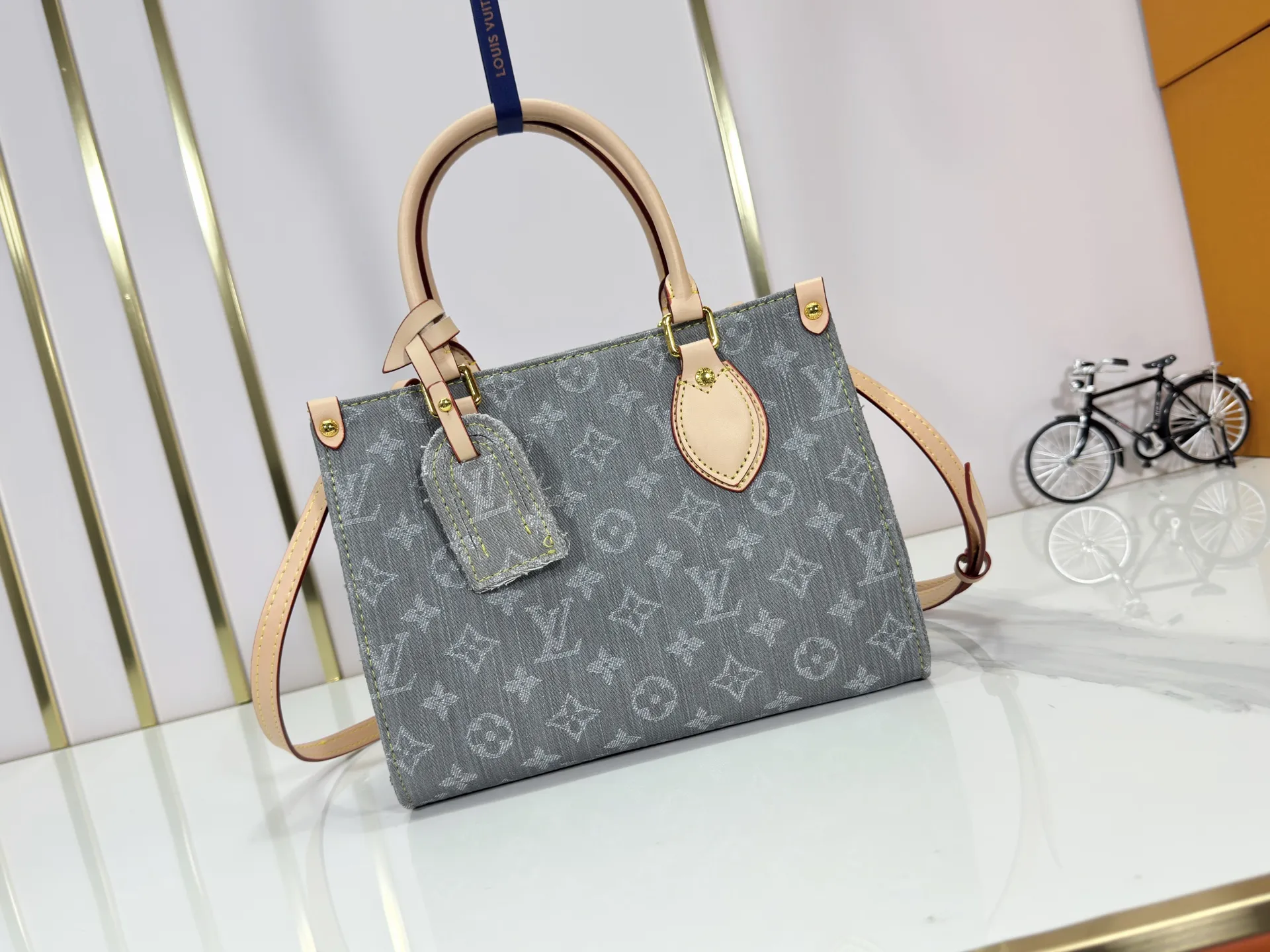 P260 Upgraded original M14633 M46373 Blue denim denim square bag This small OnTheGo handbag is made of cotton denim woven with Monogram pattern. It is bleached and sand washed to present a retro style. Detachable and Adjustable Shoulder Strap for a Subtle Fit The detachable shoulder strap makes it easy to carry small items like an iPad Mini with you. Detailed features 25x 19 x 11.5 cm.