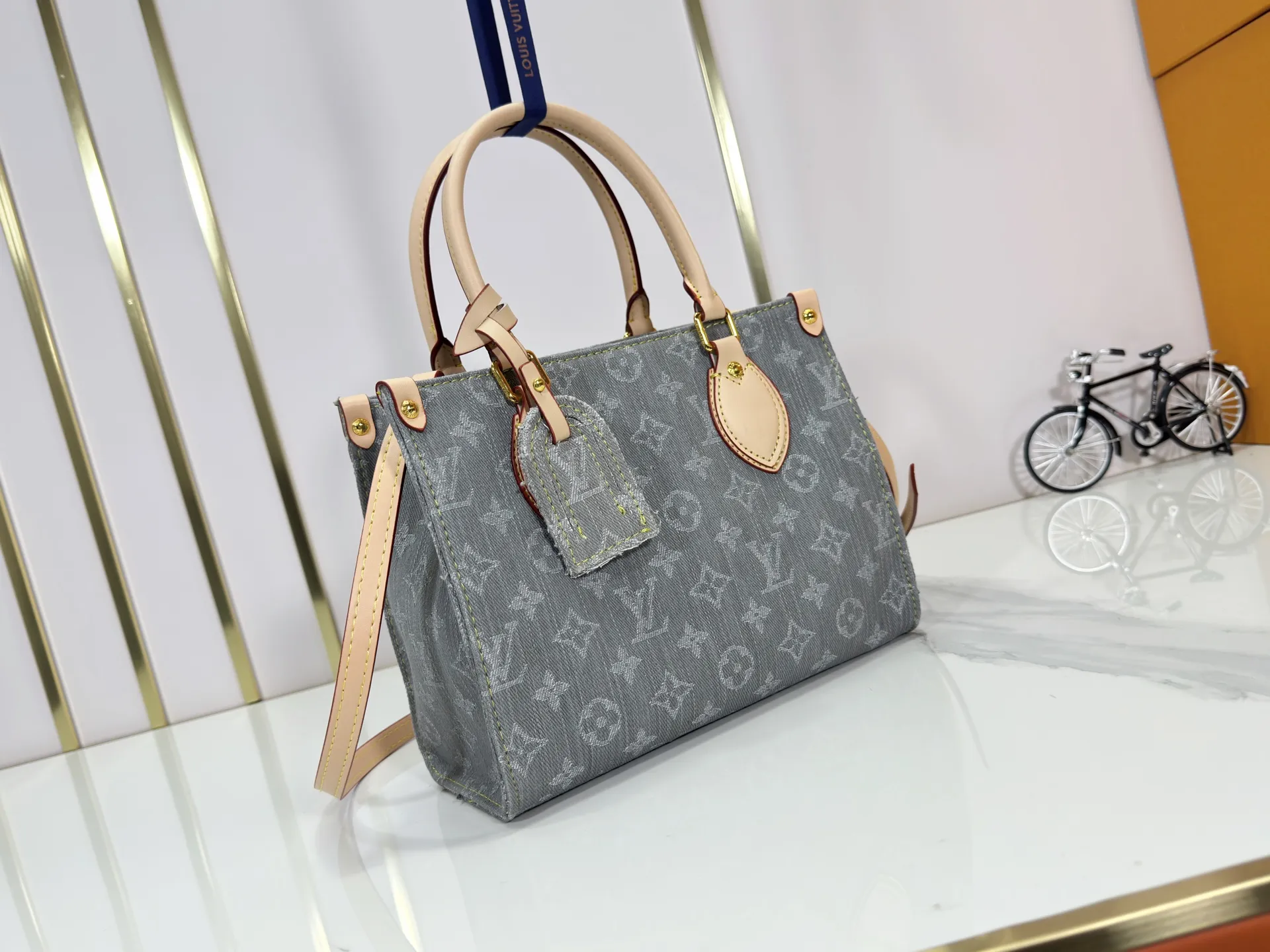 P260 Upgraded original M14633 M46373 Blue denim denim square bag This small OnTheGo handbag is made of cotton denim woven with Monogram pattern. It is bleached and sand washed to present a retro style. Detachable and Adjustable Shoulder Strap for a Subtle Fit The detachable shoulder strap makes it easy to carry small items like an iPad Mini with you. Detailed features 25x 19 x 11.5 cm.