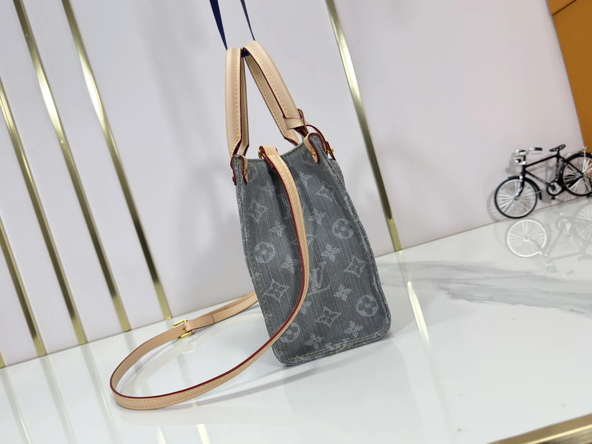 P260 Upgraded original M14633 M46373 Blue denim denim square bag This small OnTheGo handbag is made of cotton denim woven with Monogram pattern. It is bleached and sand washed to present a retro style. Detachable and Adjustable Shoulder Strap for a Subtle Fit The detachable shoulder strap makes it easy to carry small items like an iPad Mini with you. Detailed features 25x 19 x 11.5 cm.