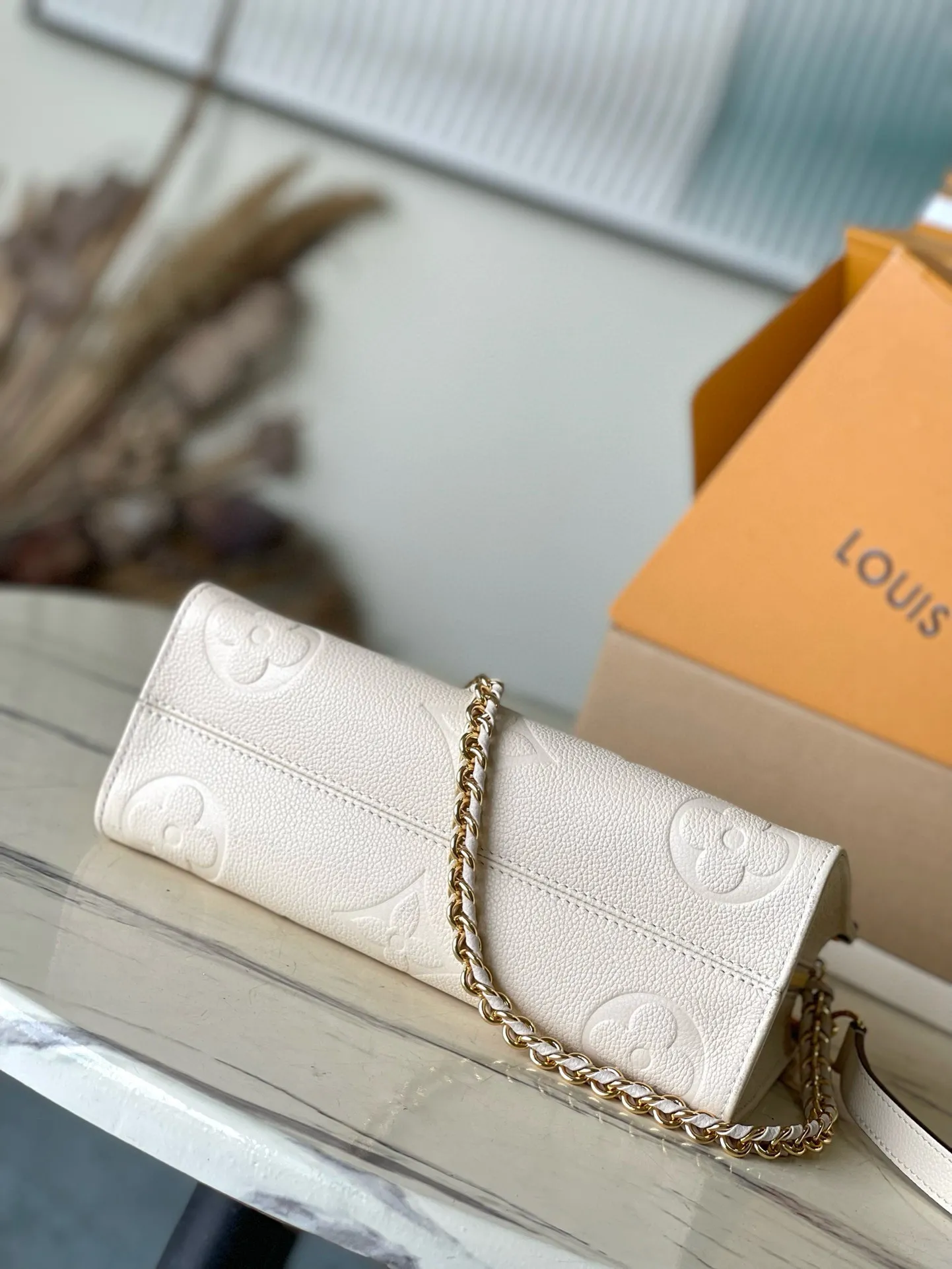 💰1100 (top layer leather) top original order M23698 off-white This small OnTheGo handbag is made of Monogram Empreinte leather embossed with Giant Monogram pattern, highlighting the soft and slender silhouette. The compact interior keeps your daily essentials organized, while the articulated top handle and detachable leather and woven chain shoulder strap allow for a variety of carrying options. Dimensions: 25 × 13 × 10 cm