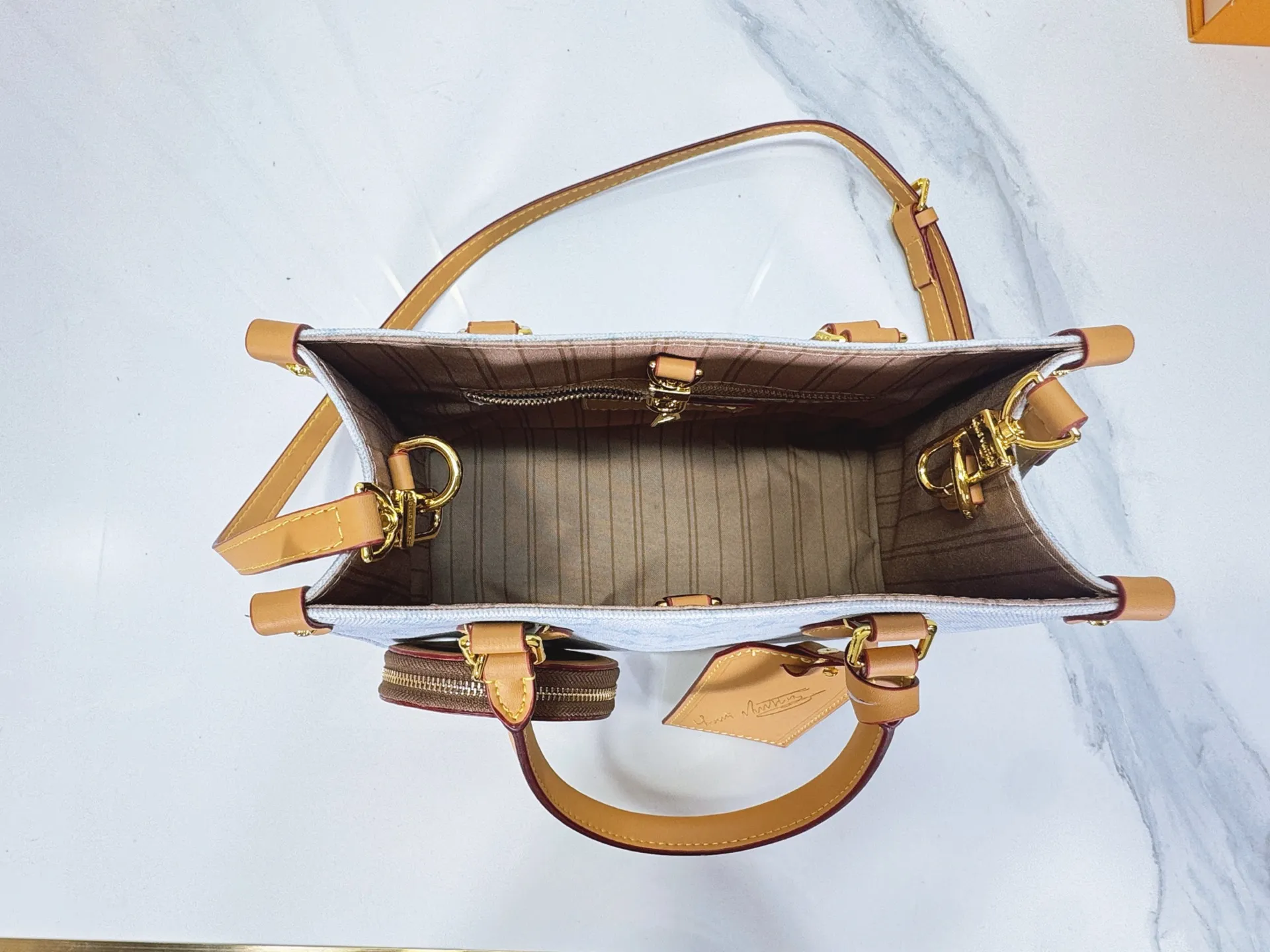 P260 upgraded original M28289 M45659 M44571 To celebrate the 130th anniversary of Louis Vuitton's Monogram pattern, this small OnTheGo handbag chooses Monogram Origine Bleu Courrier pattern canvas to reinterpret classic elements from a retro perspective. The shoulder straps, handles and address plaque are cut out of cowhide, and the striped lining and pockets open to reveal. Zipper bag securely stores valuables. Dimensions: 25 x 19 x 11.5 (cm) ((length x height x width)