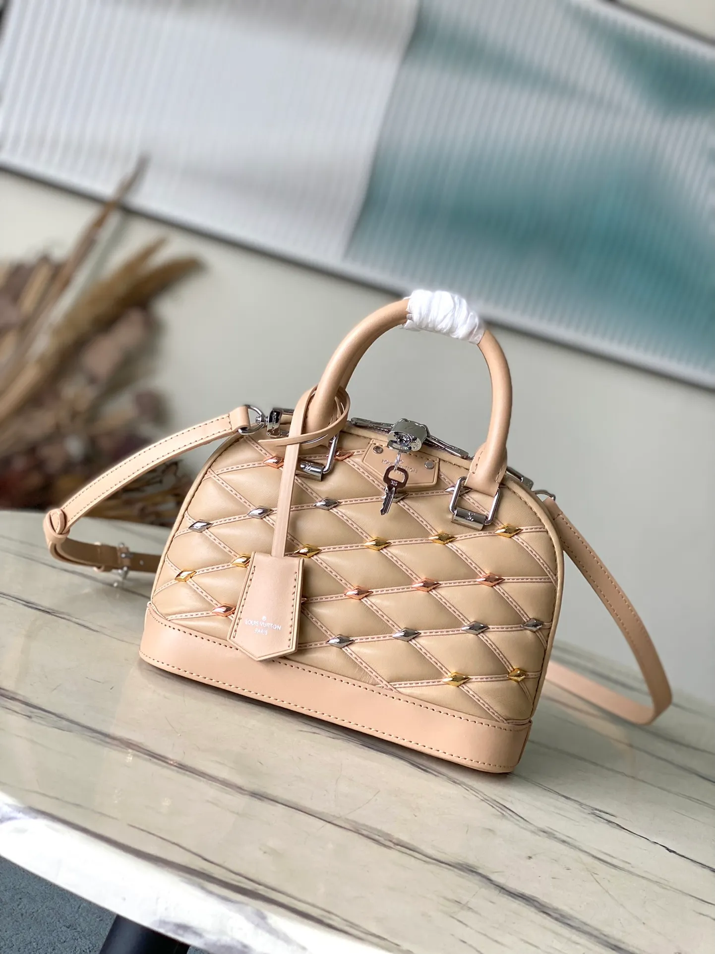 💰1180 (top layer leather) top quality original order M24153 apricot. This Alma BB handbag is made of rhombus sheepskin with bright diamond-shaped studs, which cleverly pays homage to the stitched interior design of the brand's hard luggage. Silver-pressed leather handles and removable and adjustable shoulder strap allow for comfortable carrying. Dimensions: 23.5 × 17.5 × 11.5 cm