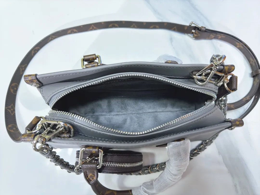 P280💰Upgraded from the original M23640 M23698 M46653 This OnTheGo East West handbag introduces the OnTheGo small tote bag design, using Monogram Empreinte leather to reinterpret the ample configuration of East West. The Giant Monogram is embossed on the leather body, and the neat interior can store daily necessities. The top handle and removable leather chain strap allow for multiple carry options. 25 x 13 x 10 cm