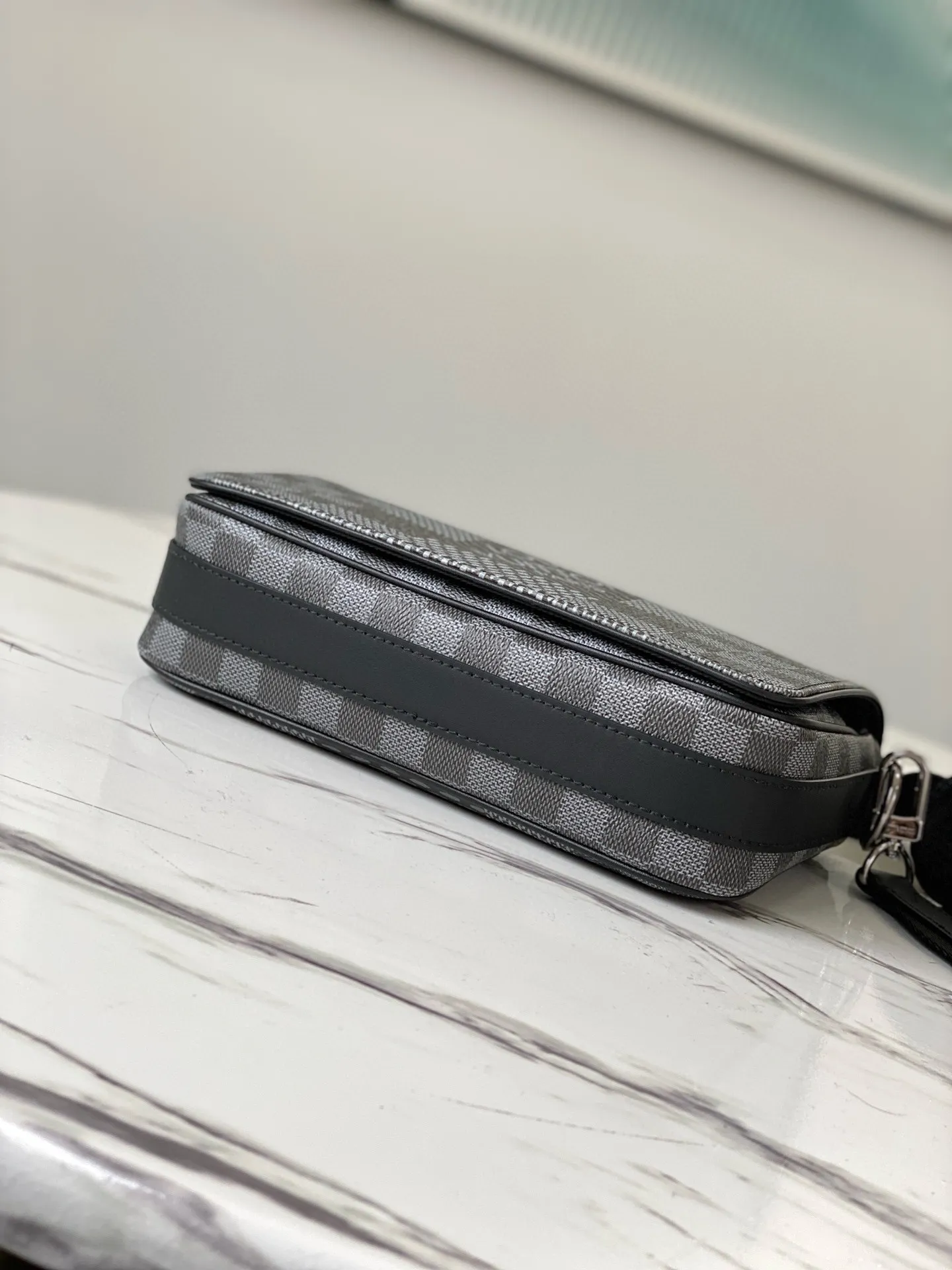 💰840 Top Original N50013 Graphite Color This Studio messenger bag is made of Damier Graphite 3D canvas, telling the modern renewal of the brand's legendary plaid. The neat structure includes ample functional space, and the detachable shoulder strap is subtly embellished with the brand logo, defining a trendy new way to store travel items. Dimensions: 23.5 x 14 x 5 cm