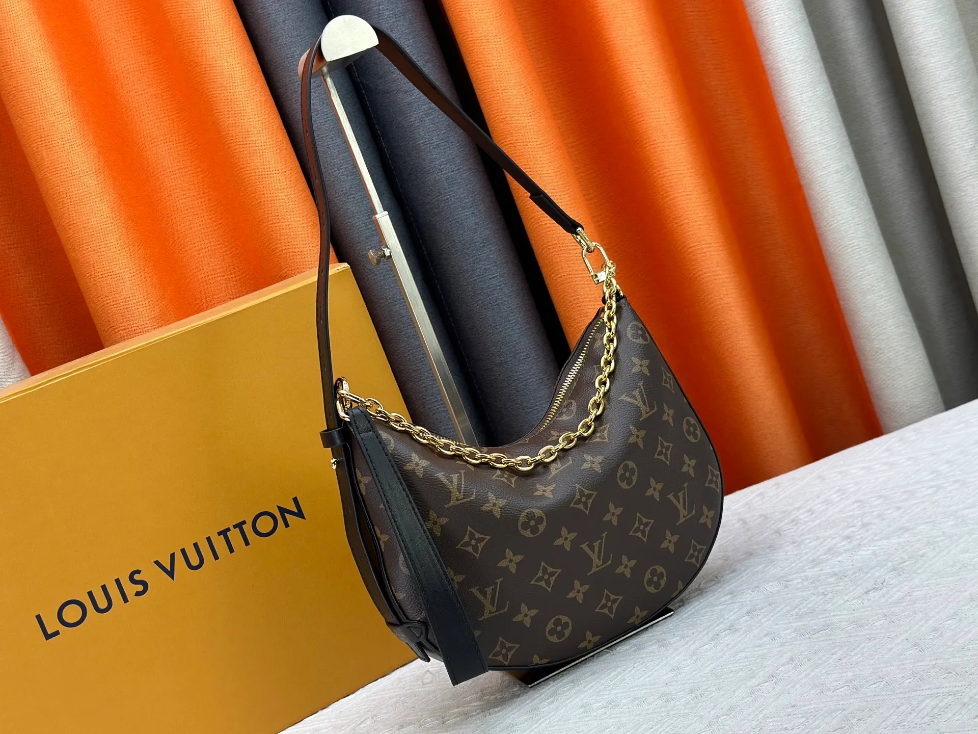 P240 Upgraded original M15056 This Cookie BB handbag is made of Monogram coated canvas, with contrasting leather trim to highlight the half-moon shape. The lightweight design combines an adjustable handle and a detachable chain to allow for easy conversion between cross-body and shoulder wear. The two ends of the bag can be connected to create a trendy wrist bag look. Dimensions: 28.5 x 19.0 x 5.0 cm (length x height x width)