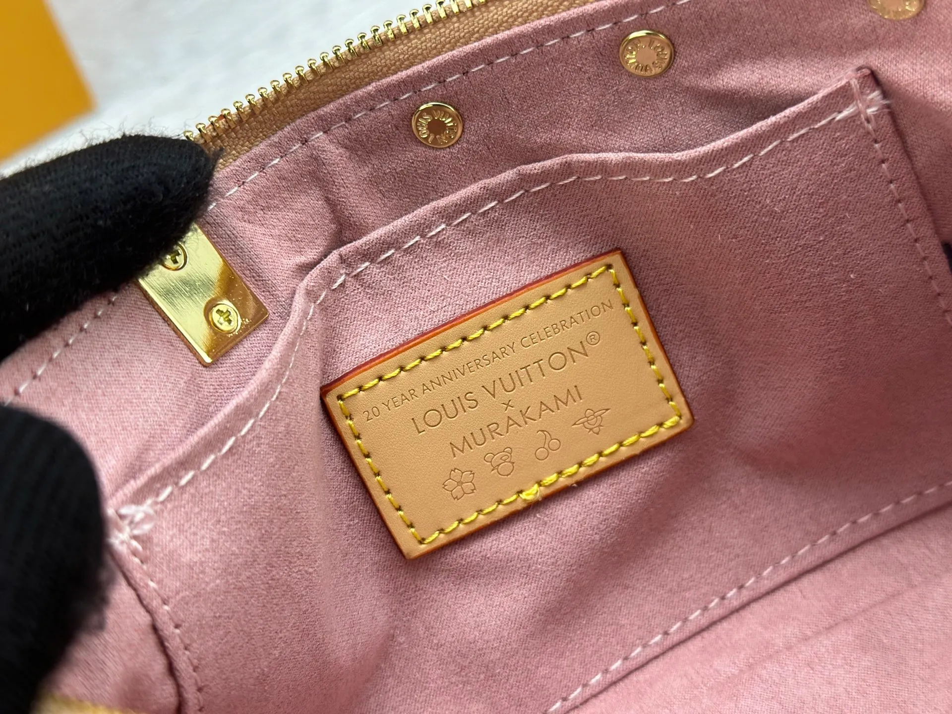 P240 M13666 This Pochette Accessoires handbag is made of classic Monogram canvas with the bright Cherry Blossom pattern written by Takashi Murakami, which brings out the distinctive elements of the Louis Vuitton x Takashi Murakami replica series in a playful style. A leather bow and LV-engraved padlock accentuate the upper edge, while dazzling studs and a detachable chain add a touch of uninhibited style. Monogram coated canvas leather trimmed fabric lining with metal hardware, zipper closure, can store a 6.7-inch smartphone and card holder. The shoulder strap is removable and not adjustable. Size: 22x13x4cm