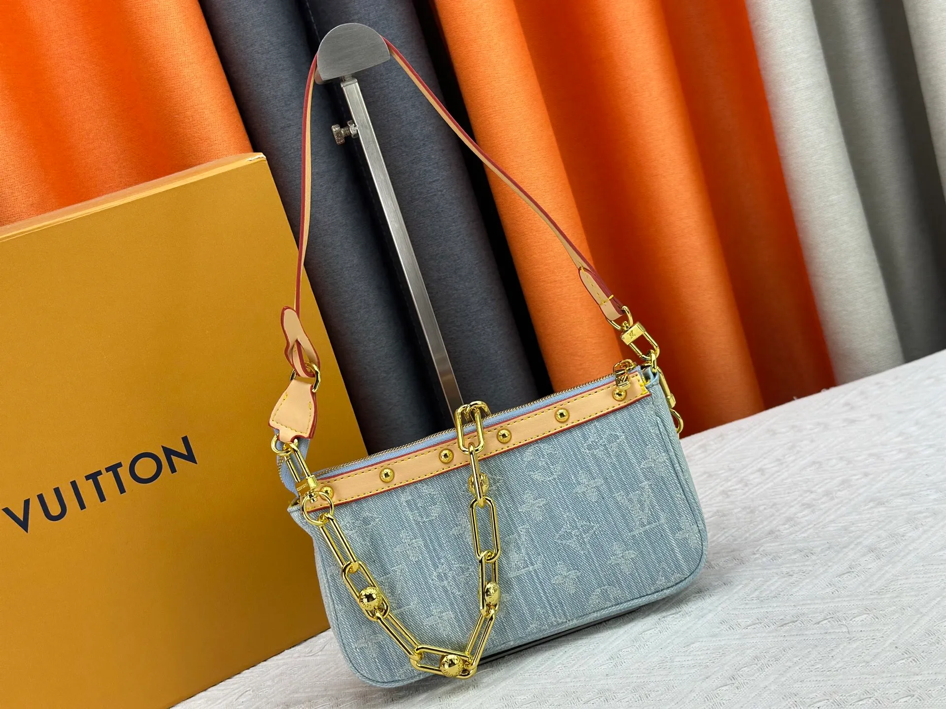 P230 M13404 Denim Denim This Pochette Accessoires handbag is made of coated canvas and uses colorful Monogram patterns to interpret the smart style of the Louis Vuitton x Murakami cross-border collaboration series. Calf leather trim and dazzling hardware add to the sophisticated details, while the detachable shoulder strap and chain provide flexible carry. Size: 22x13x4cm
