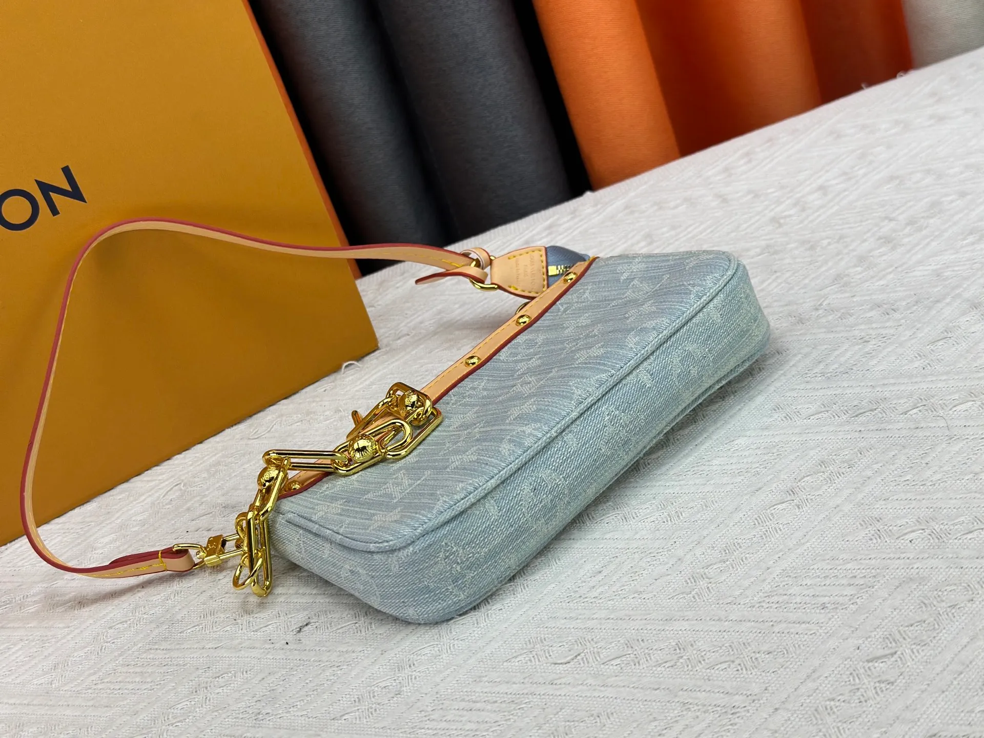 P230 M13404 Denim Denim This Pochette Accessoires handbag is made of coated canvas and uses colorful Monogram patterns to interpret the smart style of the Louis Vuitton x Murakami cross-border collaboration series. Calf leather trim and dazzling hardware add to the sophisticated details, while the detachable shoulder strap and chain provide flexible carry. Size: 22x13x4cm