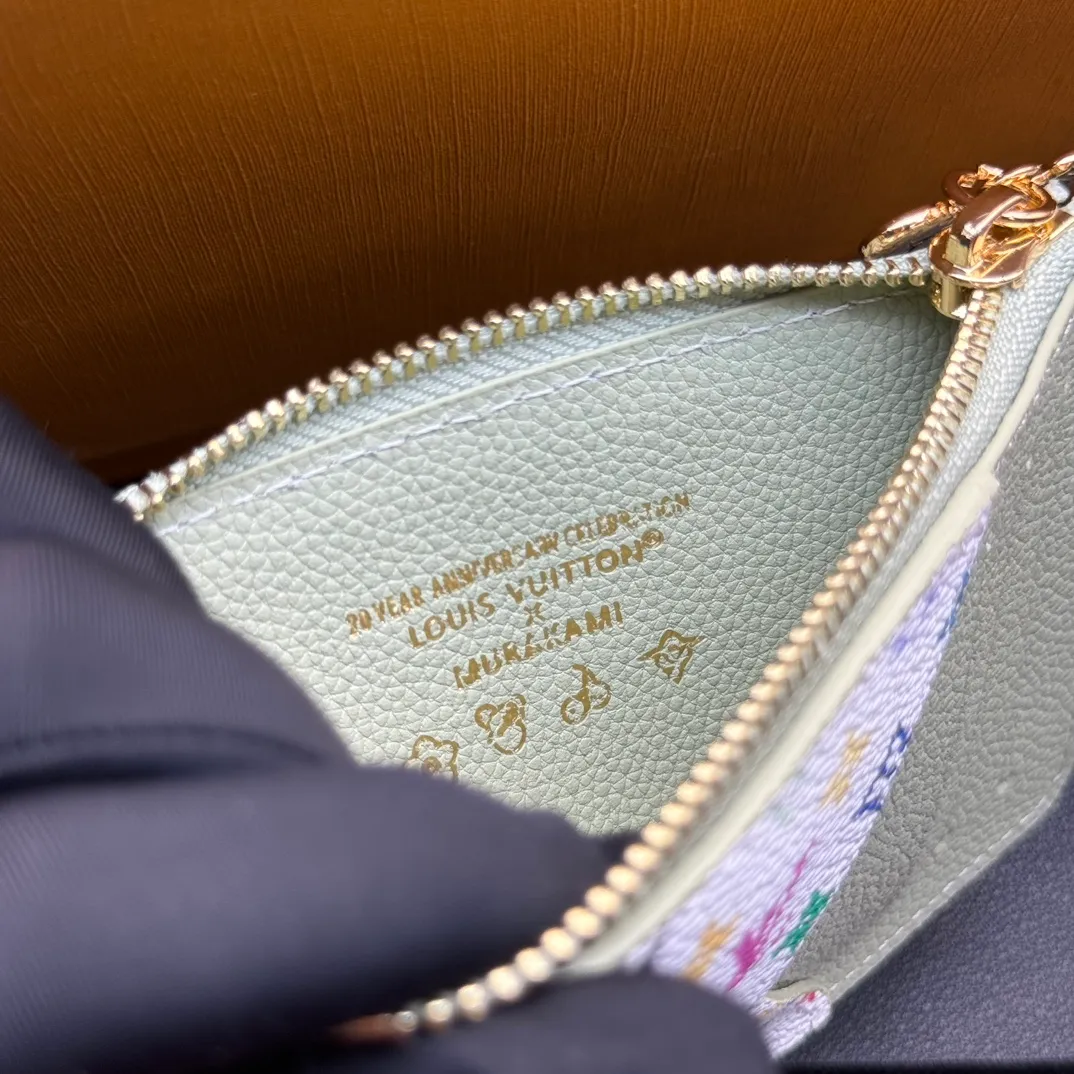 💰140 💎Top Original #Green 🇫🇷 This Romy card holder is from the Louis Vuitton x Takashi Murakami cross-border collaboration series. It renders fresh colors for Monogram Empreinte leather, subtly paying tribute to the rainbow tones painted by Japanese artists. Colorful Monogram coated canvas accents the patch pockets, and the panda-shaped zipper pull of the zippered coin bag adds new season interest. Model: M13800 Dimensions: 8 x 0.8 x 12 cm (H x W x Length)