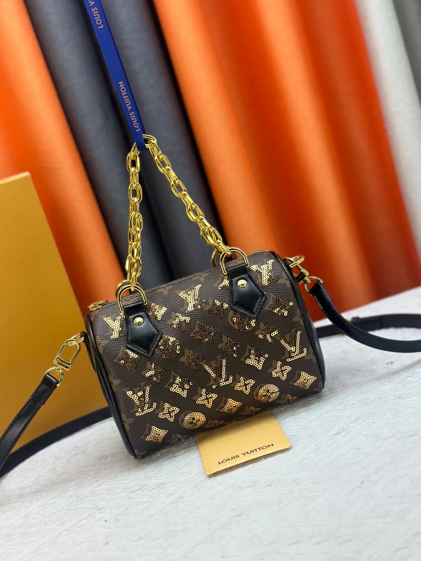 P360 upgraded original M58953 gold sequins M46234 M14291 Speedy Bandoulière 20 handbag is made of soft coated canvas, and the full-length Monogram pattern is traced in colorful rainbow tones, highlighting the smart style of the Louis Vuitton x Murakami reissue series. The Toron handle and detachable shoulder strap are constructed of cow leather, the metal corners recall classic luggage elements, and the bow-shaped key bag and padlock add brand touches. Dimensions: 20.5 x 13.5 x 12.0 cm (length x height x width)