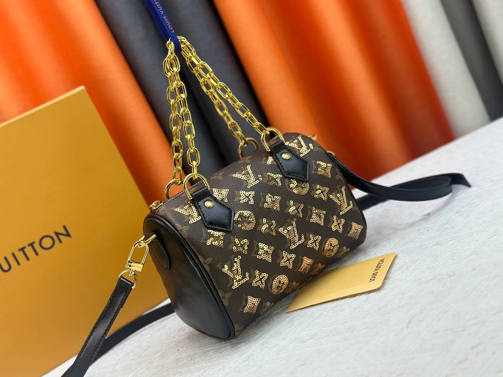 P360 upgraded original M58953 gold sequins M46234 M14291 Speedy Bandoulière 20 handbag is made of soft coated canvas, and the full-length Monogram pattern is traced in colorful rainbow tones, highlighting the smart style of the Louis Vuitton x Murakami reissue series. The Toron handle and detachable shoulder strap are constructed of cow leather, the metal corners recall classic luggage elements, and the bow-shaped key bag and padlock add brand touches. Dimensions: 20.5 x 13.5 x 12.0 cm (length x height x width)