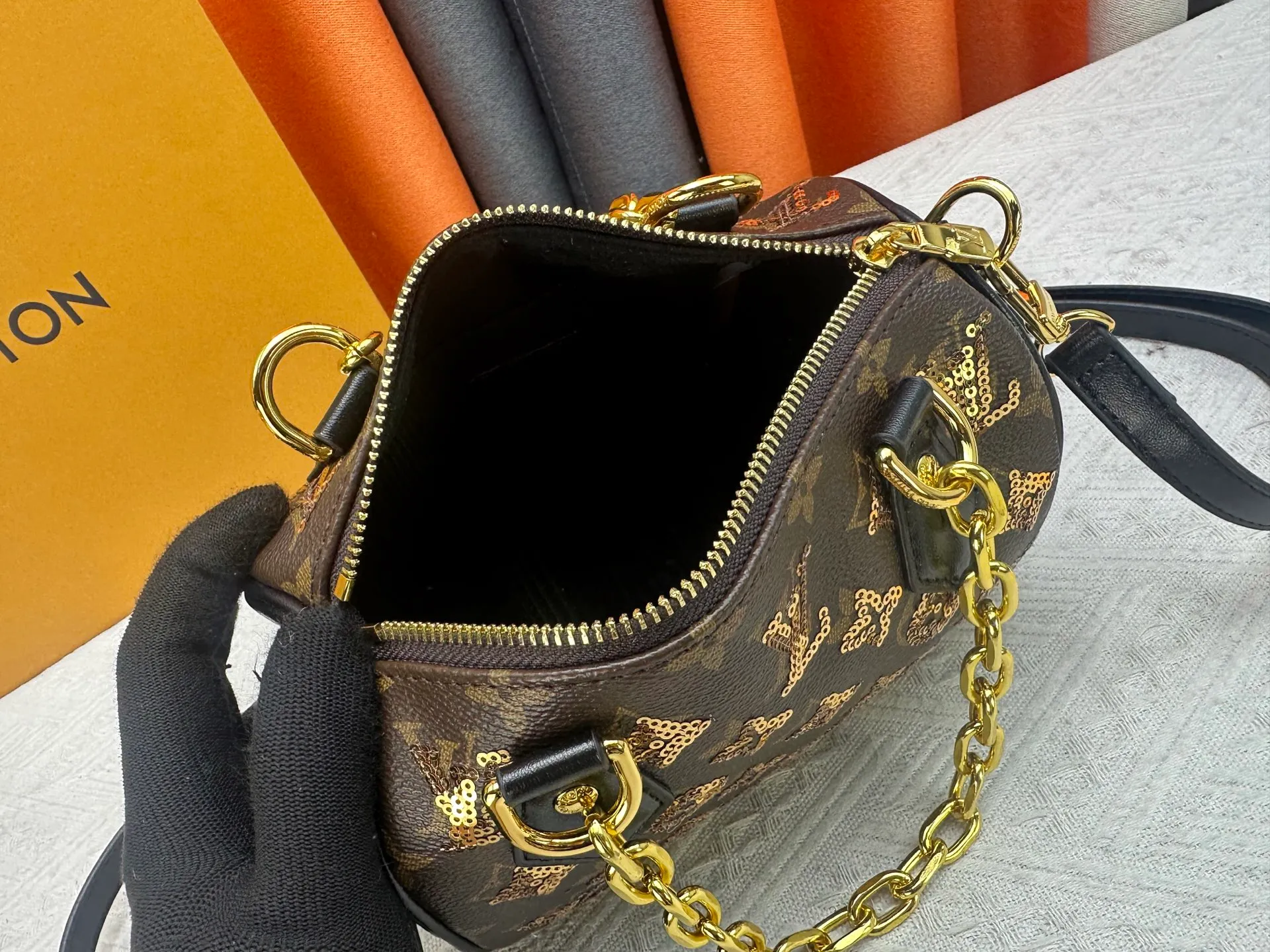 P360 upgraded original M58953 gold sequins M46234 M14291 Speedy Bandoulière 20 handbag is made of soft coated canvas, and the full-length Monogram pattern is traced in colorful rainbow tones, highlighting the smart style of the Louis Vuitton x Murakami reissue series. The Toron handle and detachable shoulder strap are constructed of cow leather, the metal corners recall classic luggage elements, and the bow-shaped key bag and padlock add brand touches. Dimensions: 20.5 x 13.5 x 12.0 cm (length x height x width)