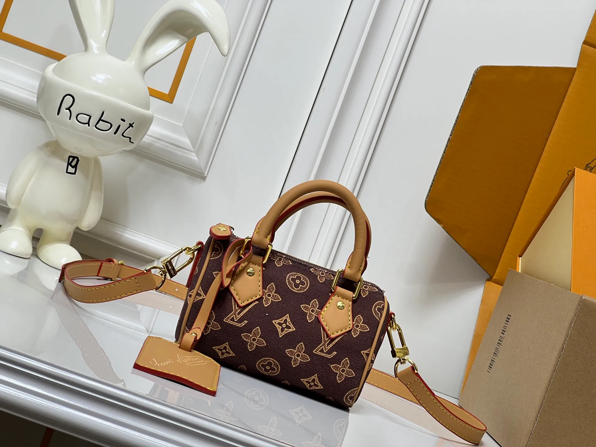 Batch 240💰M28322 Red M28323 M27610 M81085 [Exclusive background shot] This Nano Speedy handbag condenses the configuration of Louis Vuitton's classic Speedy handbag. It is made of Monogram canvas with distressed cow leather details and dazzling metal parts, making it easy to carry with you for daily needs. The handles and removable and adjustable shoulder strap allow for a variety of styling possibilities. 16.0 x 10.0 x 7.5 cm (L x H x W) • Monogram coated canvas • Cow leather trim • Metal hardware • Zipper closure • Space to store daily necessities such as a 6.1-inch smartphone, card holder and lipstick • Shoulder strap: removable, adjustable • Half-length strap: 45.5 cm • Half-length strap adjustable to: 54.0 cm • Handle: Double handle