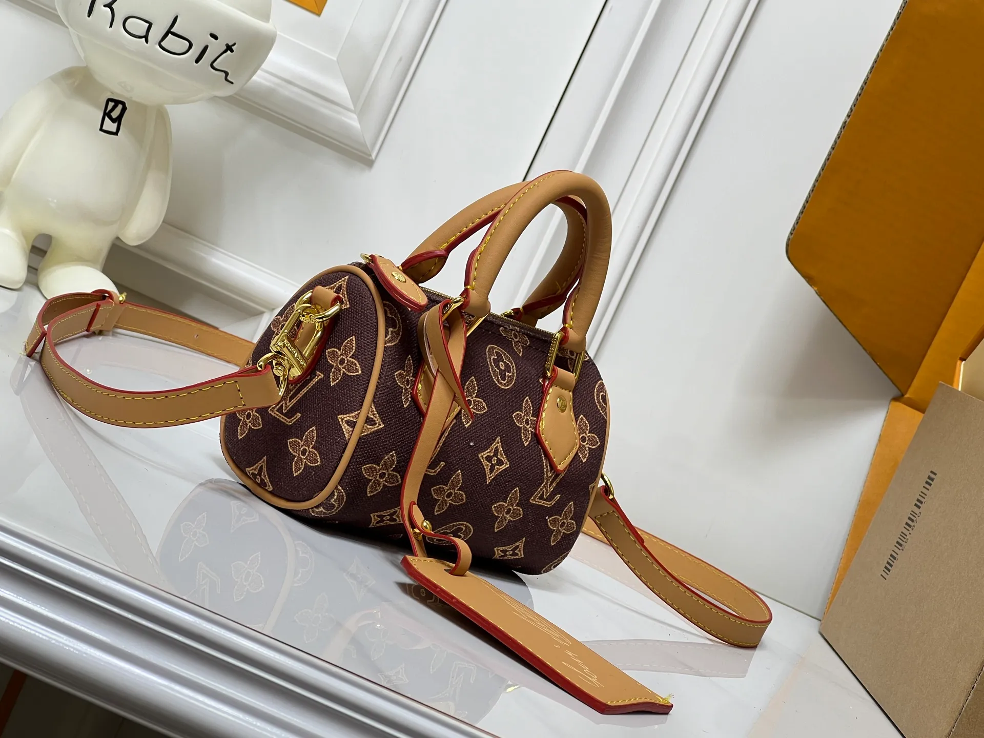 Batch 240💰M28322 Red M28323 M27610 M81085 [Exclusive background shot] This Nano Speedy handbag condenses the configuration of Louis Vuitton's classic Speedy handbag. It is made of Monogram canvas with distressed cow leather details and dazzling metal parts, making it easy to carry with you for daily needs. The handles and removable and adjustable shoulder strap allow for a variety of styling possibilities. 16.0 x 10.0 x 7.5 cm (L x H x W) • Monogram coated canvas • Cow leather trim • Metal hardware • Zipper closure • Space to store daily necessities such as a 6.1-inch smartphone, card holder and lipstick • Shoulder strap: removable, adjustable • Half-length strap: 45.5 cm • Half-length strap adjustable to: 54.0 cm • Handle: Double handle