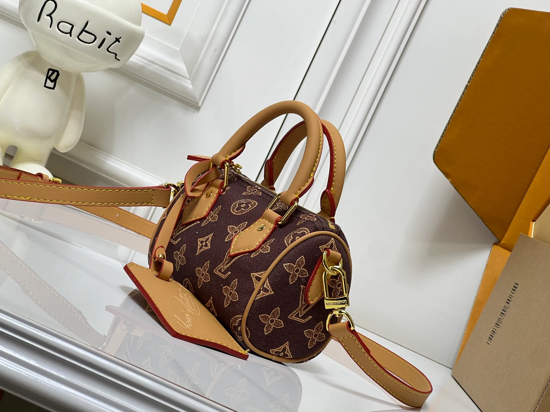 Batch 240💰M28322 Red M28323 M27610 M81085 [Exclusive background shot] This Nano Speedy handbag condenses the configuration of Louis Vuitton's classic Speedy handbag. It is made of Monogram canvas with distressed cow leather details and dazzling metal parts, making it easy to carry with you for daily needs. The handles and removable and adjustable shoulder strap allow for a variety of styling possibilities. 16.0 x 10.0 x 7.5 cm (L x H x W) • Monogram coated canvas • Cow leather trim • Metal hardware • Zipper closure • Space to store daily necessities such as a 6.1-inch smartphone, card holder and lipstick • Shoulder strap: removable, adjustable • Half-length strap: 45.5 cm • Half-length strap adjustable to: 54.0 cm • Handle: Double handle