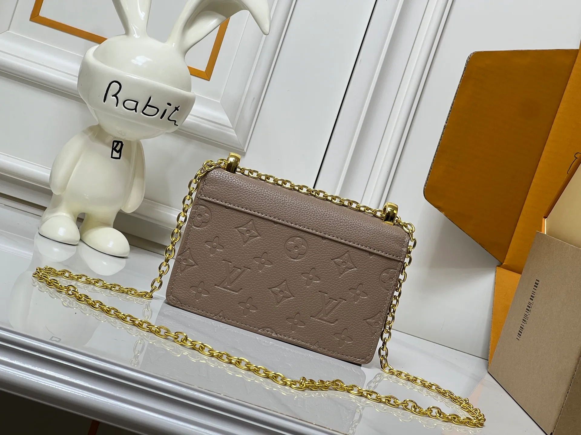 Batch 220💰M13569 black M13570 gray M25814 burgundy (chain/embossed) [Portefeuille chaîne Rosy] This Rosy chain wallet is both fashionable and practical, adding a modern spirit to the Monogram Empreinte series. It has an elegant LV circle and a V-shaped flap, two hallmarks of the house. The magnetic closure reveals a surprise Monogram flower, as well as three card slots and a flat interior pocket. The sliding chain allows you to wear it crosswise or over the shoulder.  Dimensions: 19.5 x 13.5 x 6.5 cm