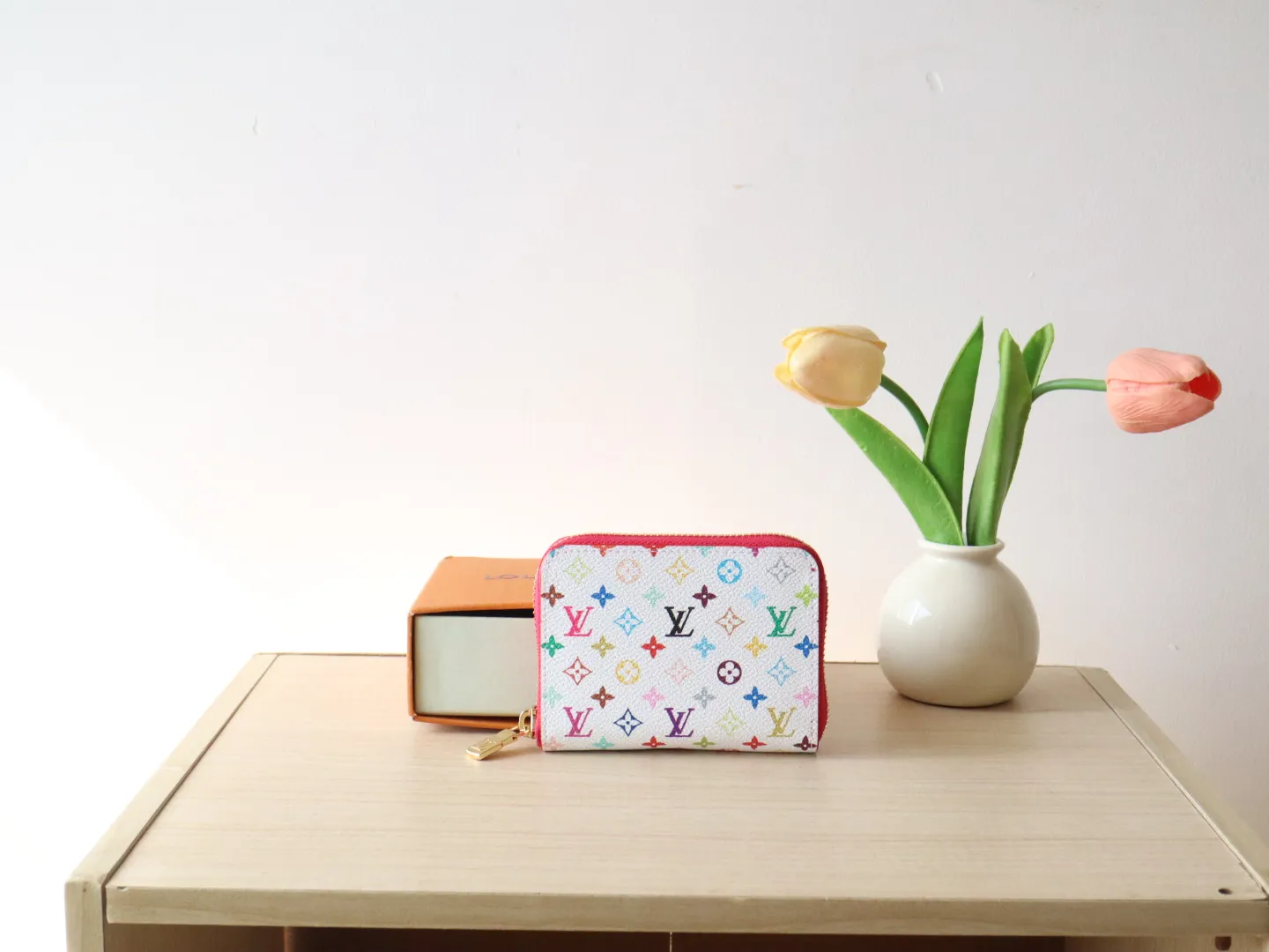 13409 Tricolor Short Zipper Style 🌟P88 LV x TM Zippy Coin Purse M13409 White Color (Tricolor - Murakami) As part of the Louis Vuitton x Murakami series reissue, the timeless Zippy coin purse is practical and playful, upgraded for this season. It's made from Monogram coated canvas in a cheerful rainbow of hues, in keeping with the Japanese artist's signature pop palette. The interior is secured with a silver zipper and is divided into multiple compartments for coins, banknotes and cards. Dimensions: 11 x 8.5 x 2 cm.