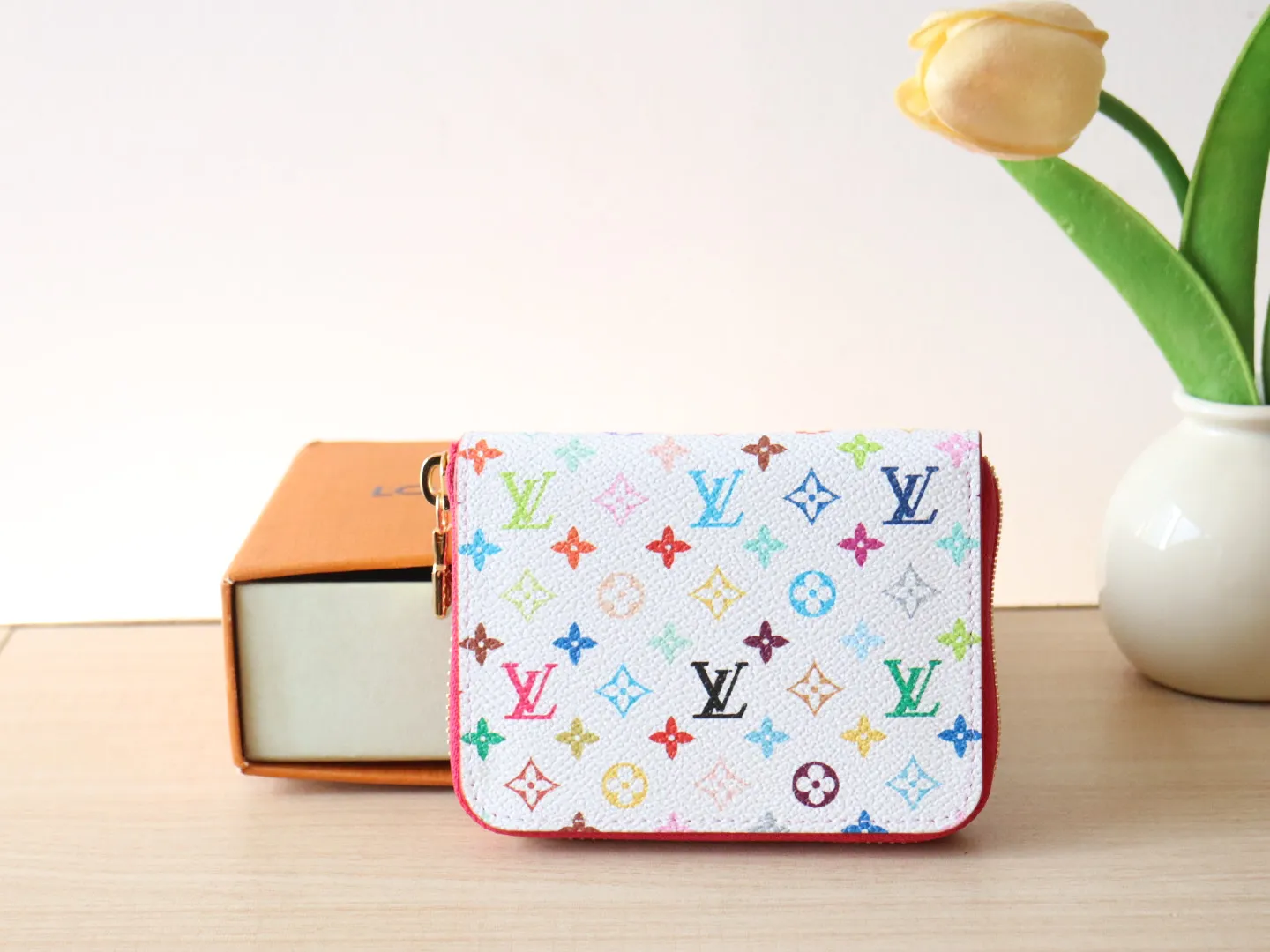 13409 Tricolor Short Zipper Style 🌟P88 LV x TM Zippy Coin Purse M13409 White Color (Tricolor - Murakami) As part of the Louis Vuitton x Murakami series reissue, the timeless Zippy coin purse is practical and playful, upgraded for this season. It's made from Monogram coated canvas in a cheerful rainbow of hues, in keeping with the Japanese artist's signature pop palette. The interior is secured with a silver zipper and is divided into multiple compartments for coins, banknotes and cards. Dimensions: 11 x 8.5 x 2 cm.